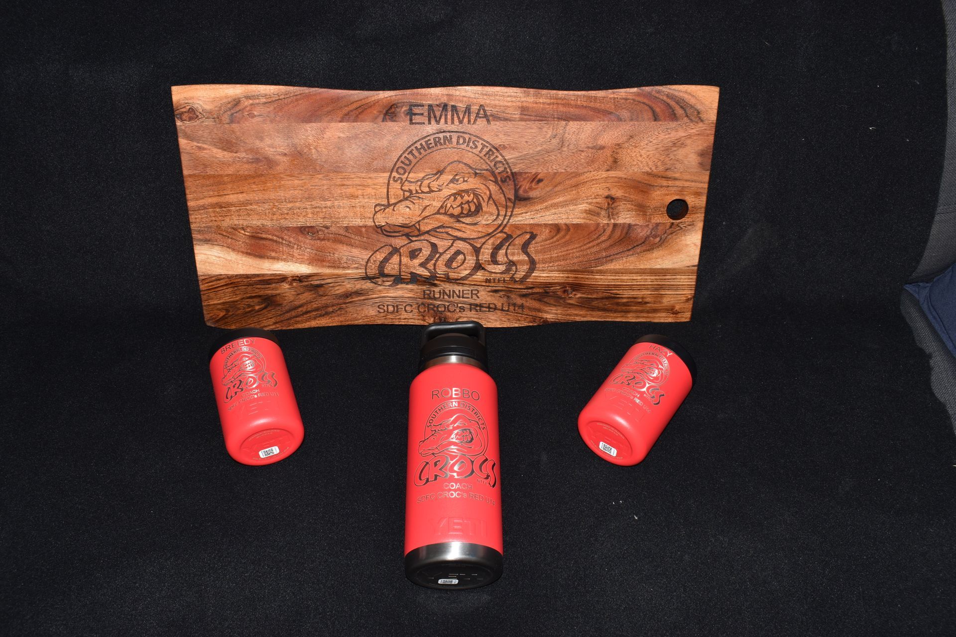 Three red shotgun shell casings and a wooden plaque with engraved text on a black background — Advanced Poly in Darwin, NT 