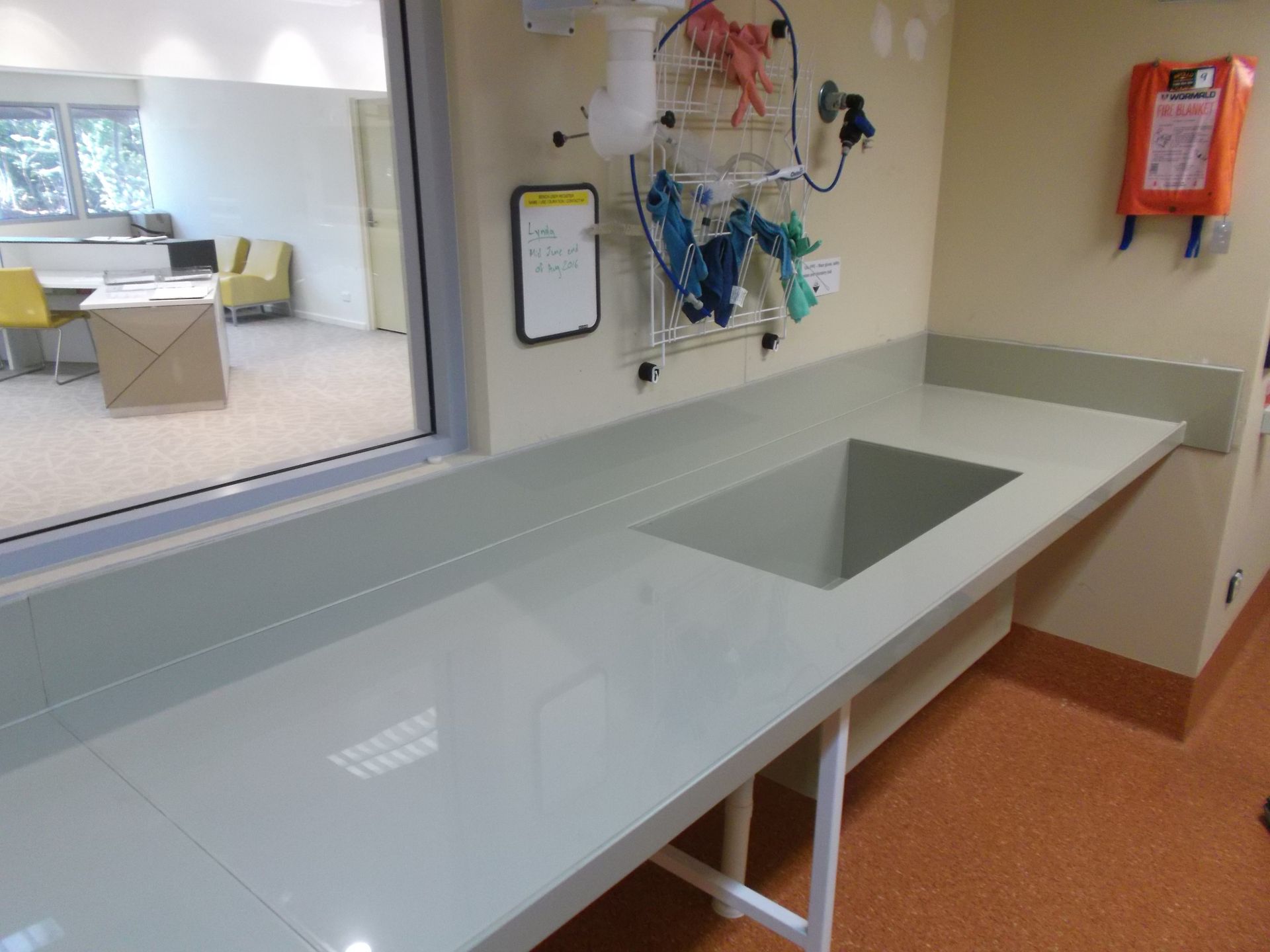 White office counter with built-in sink beside a window and wall-mounted artwork in a modern room — Advanced Poly in Darwin, NT