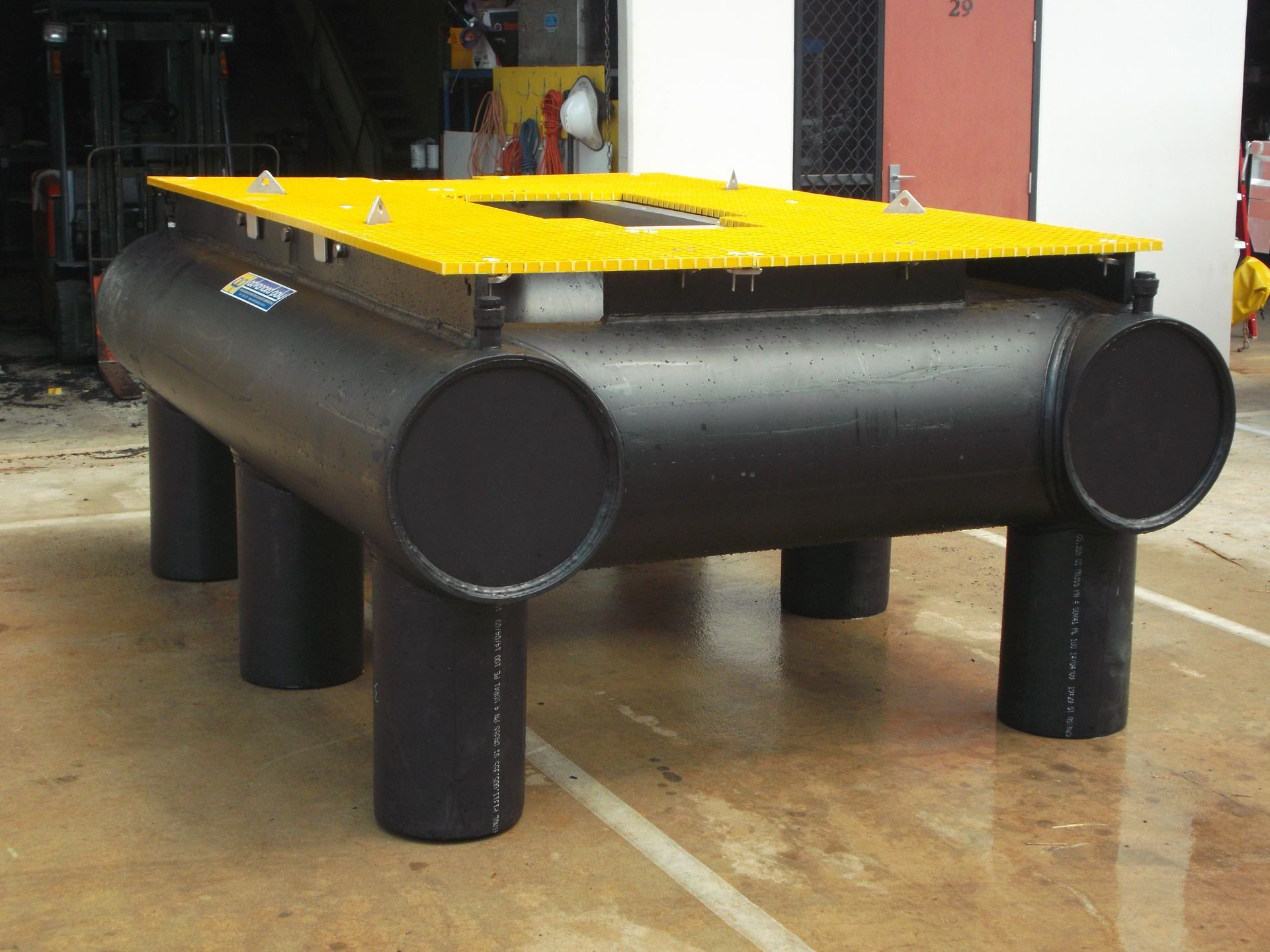 Yellow-topped black floating dock made of large cylindrical barrels in a workshop — Advanced Poly in Darwin, NT — Advanced Poly in Darwin, NT — Advanced Poly in Darwin, NT — Advanced Poly in Darwin, NT — Advanced Poly in Darwin, NT 