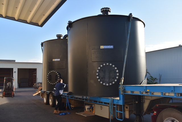 Large black industrial tanks on a flatbed truck at a warehouse, with workers nearby. — Advanced Poly in Darwin, NT — Advanced Poly in Darwin, NT — Advanced Poly in Darwin, NT — Advanced Poly in Darwin, NT — Advanced Poly in Darwin, NT 
