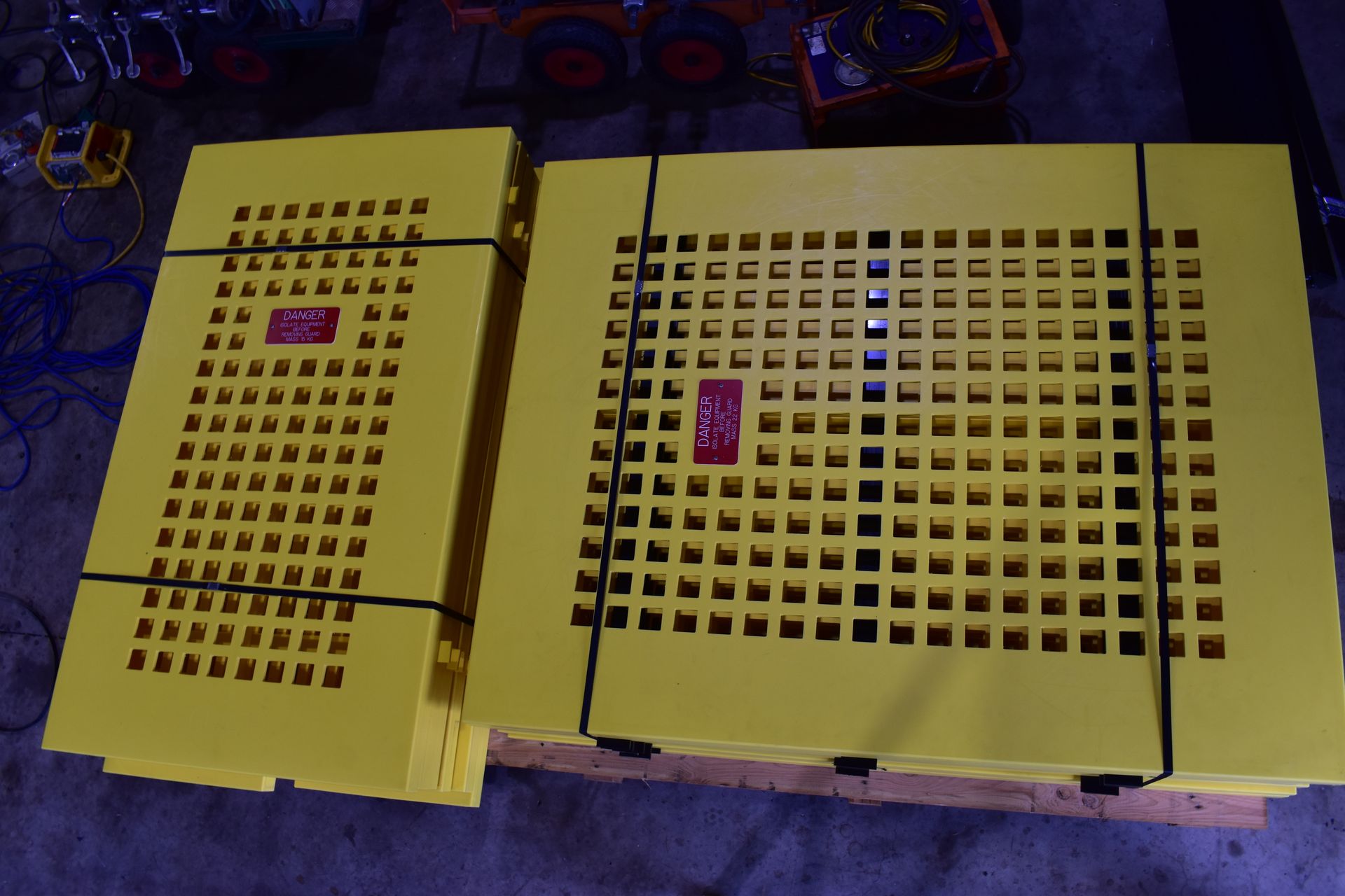 Two yellow plastic crate panels with grid holes and labels, lying on a blue carpet. — Advanced Poly in Darwin, NT