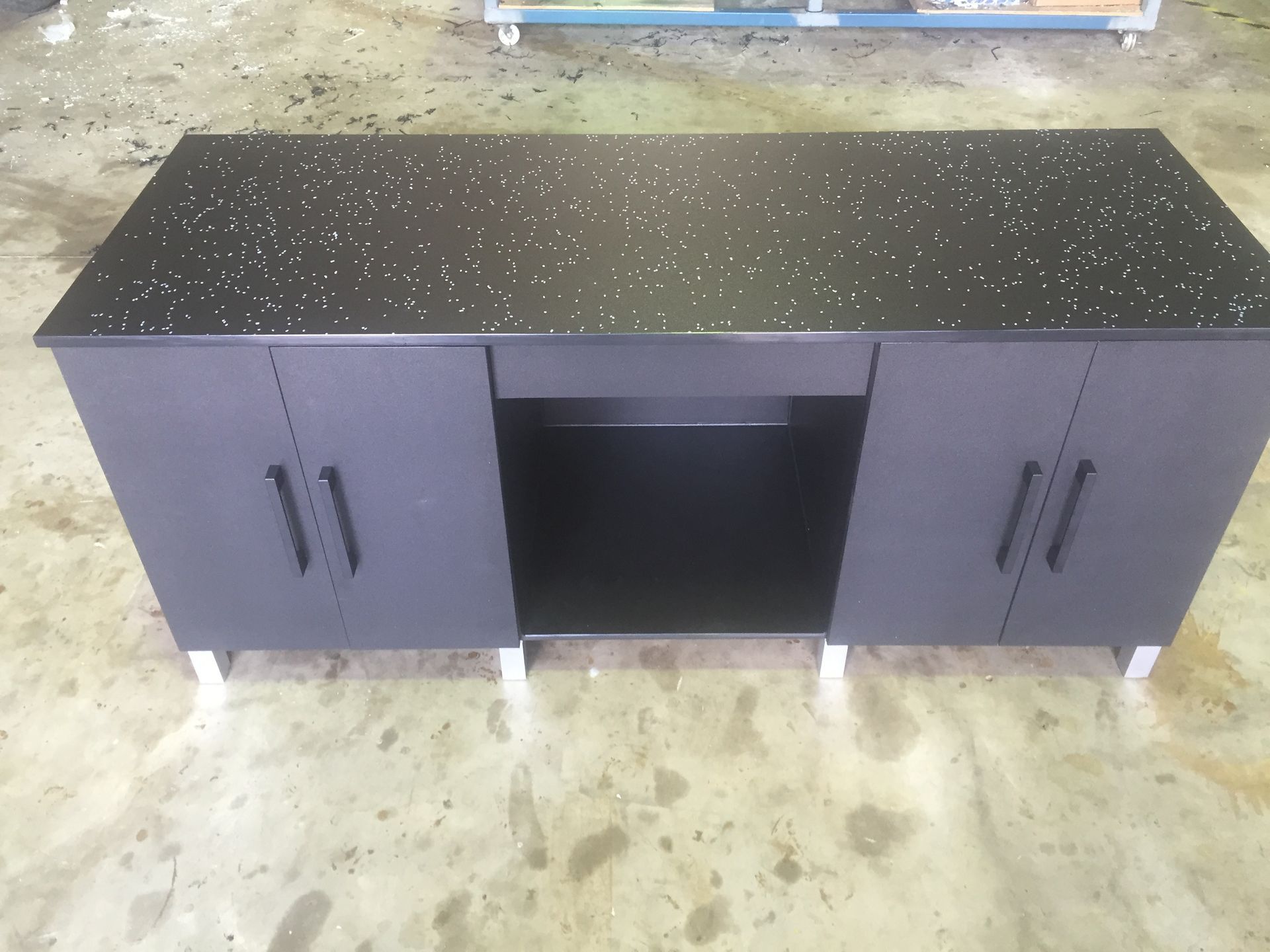 Black speckled cabinet with central open shelf and two side doors on a concrete floor. — Advanced Poly in Darwin, NT