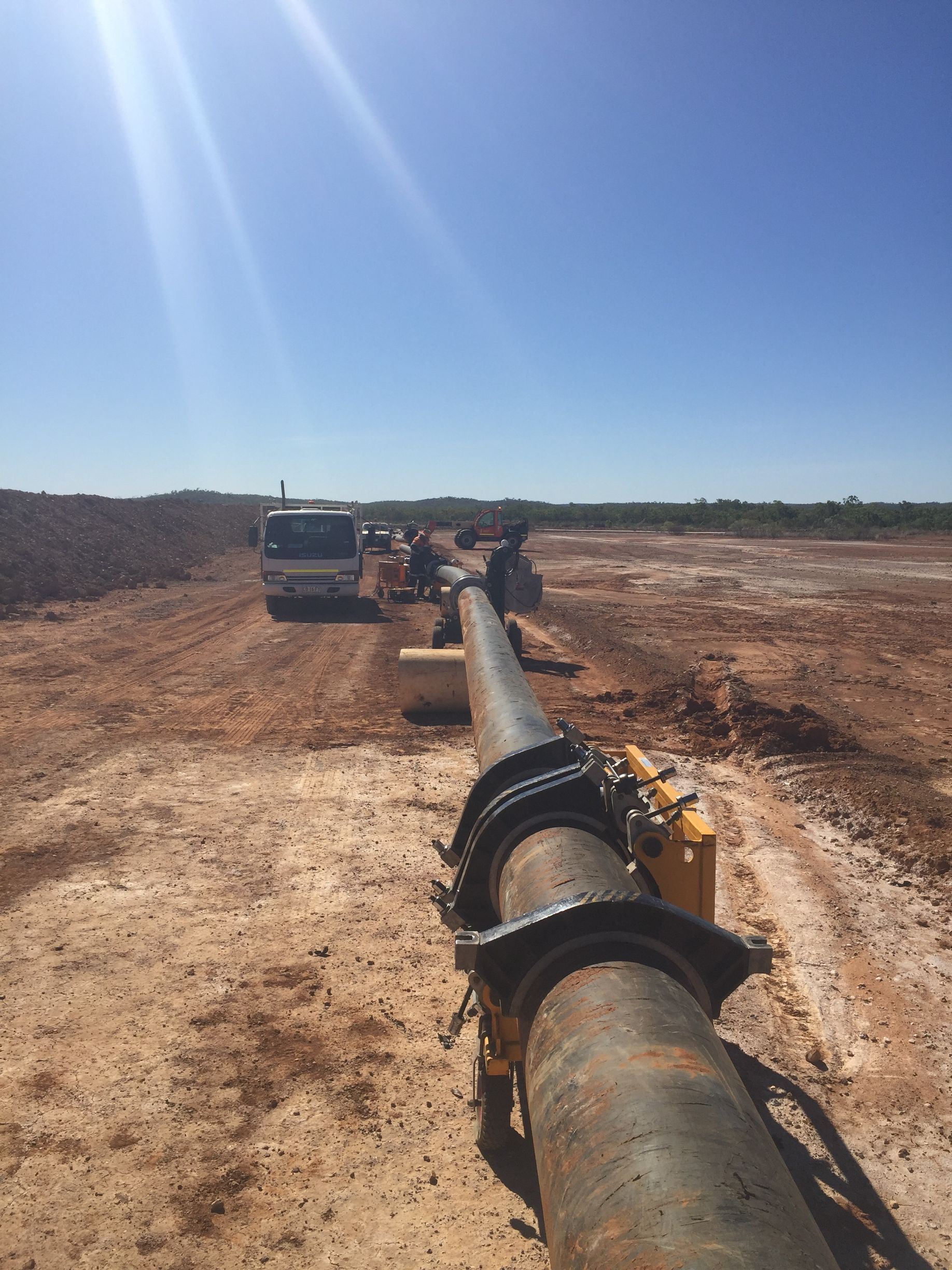 Large pipeline being installed across a dry construction site under a bright blue sky — Advanced Poly in Darwin, NT