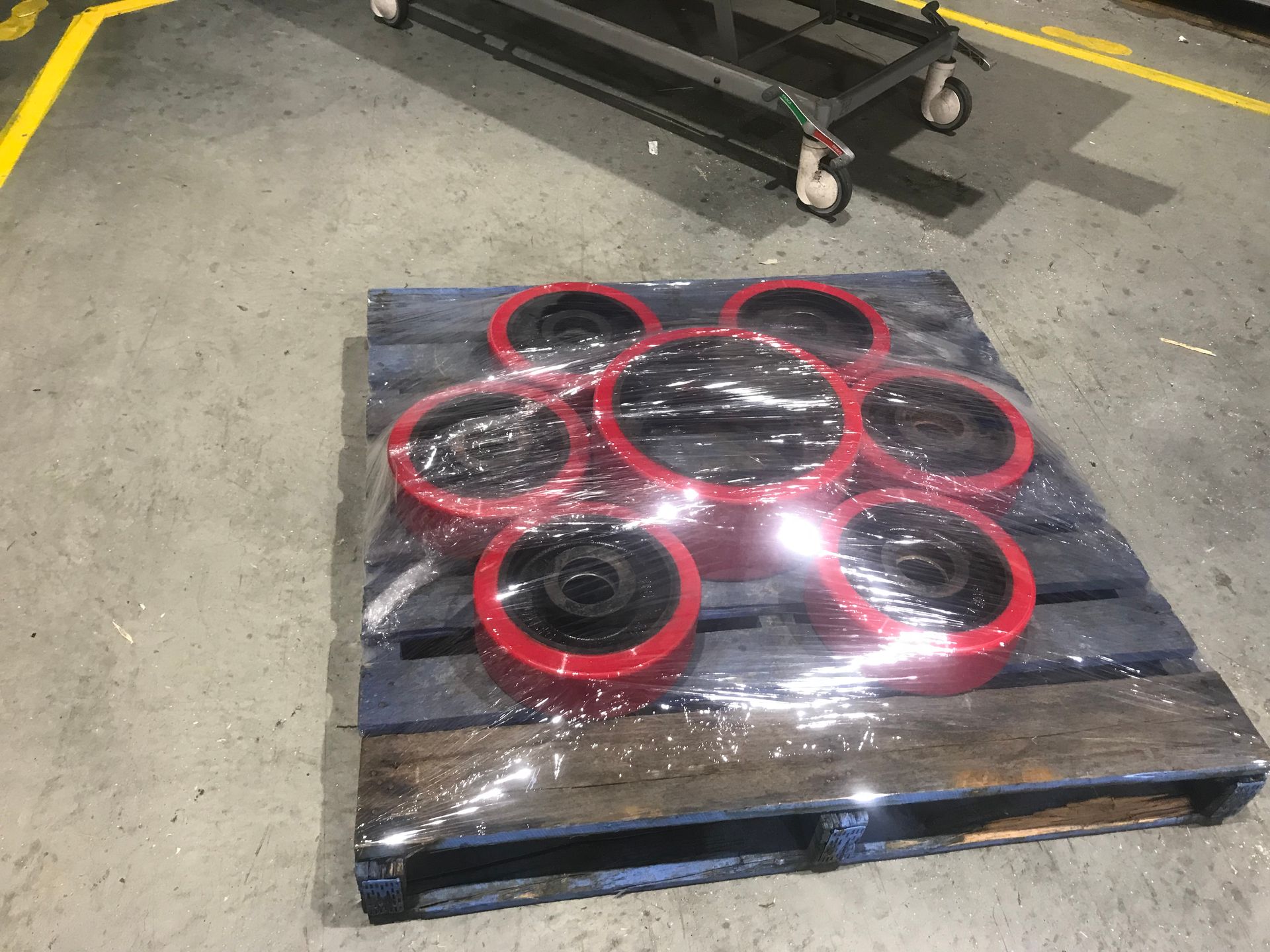 Wooden pallet holding a black and red circular-patterned item on a concrete floor in a warehouse. — Advanced Poly in Darwin, NT
