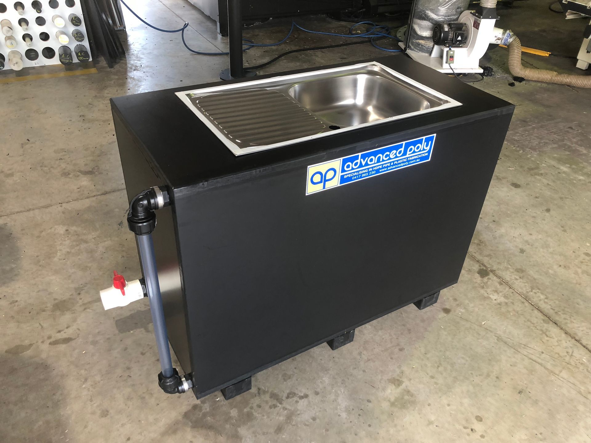 Black wheeled stainless-steel sink cart with a single basin in an industrial workshop — Advanced Poly in Darwin, NT