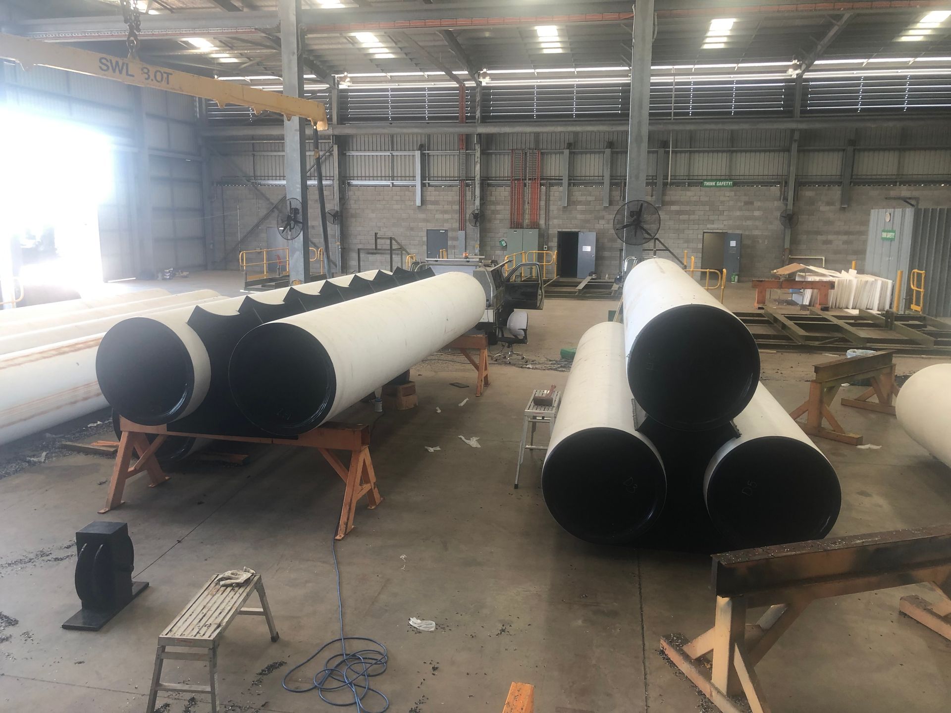 Large white industrial pipes being assembled in a warehouse workshop. — Advanced Poly in Darwin, NT