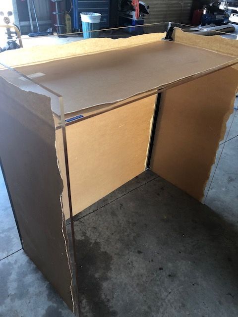 Cardboard box enclosure with an open front, taped seams, and a flat top on a concrete floor. — Advanced Poly in Darwin, NT — Advanced Poly in Darwin, NT 