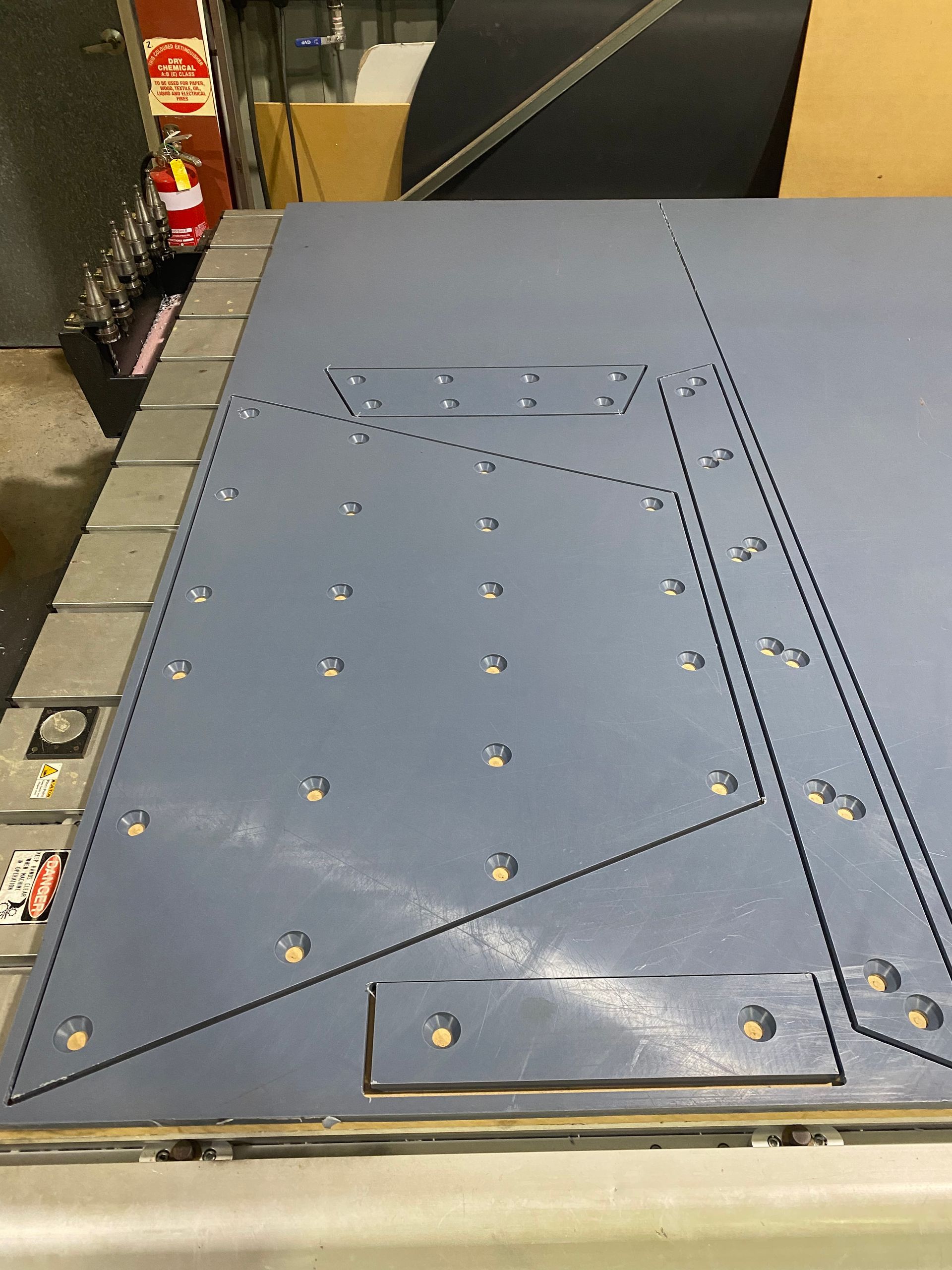 Blue metal panel with rows of bolts and a triangular seam on an industrial floor — Advanced Poly in Darwin, NT — Advanced Poly in Darwin, NT
