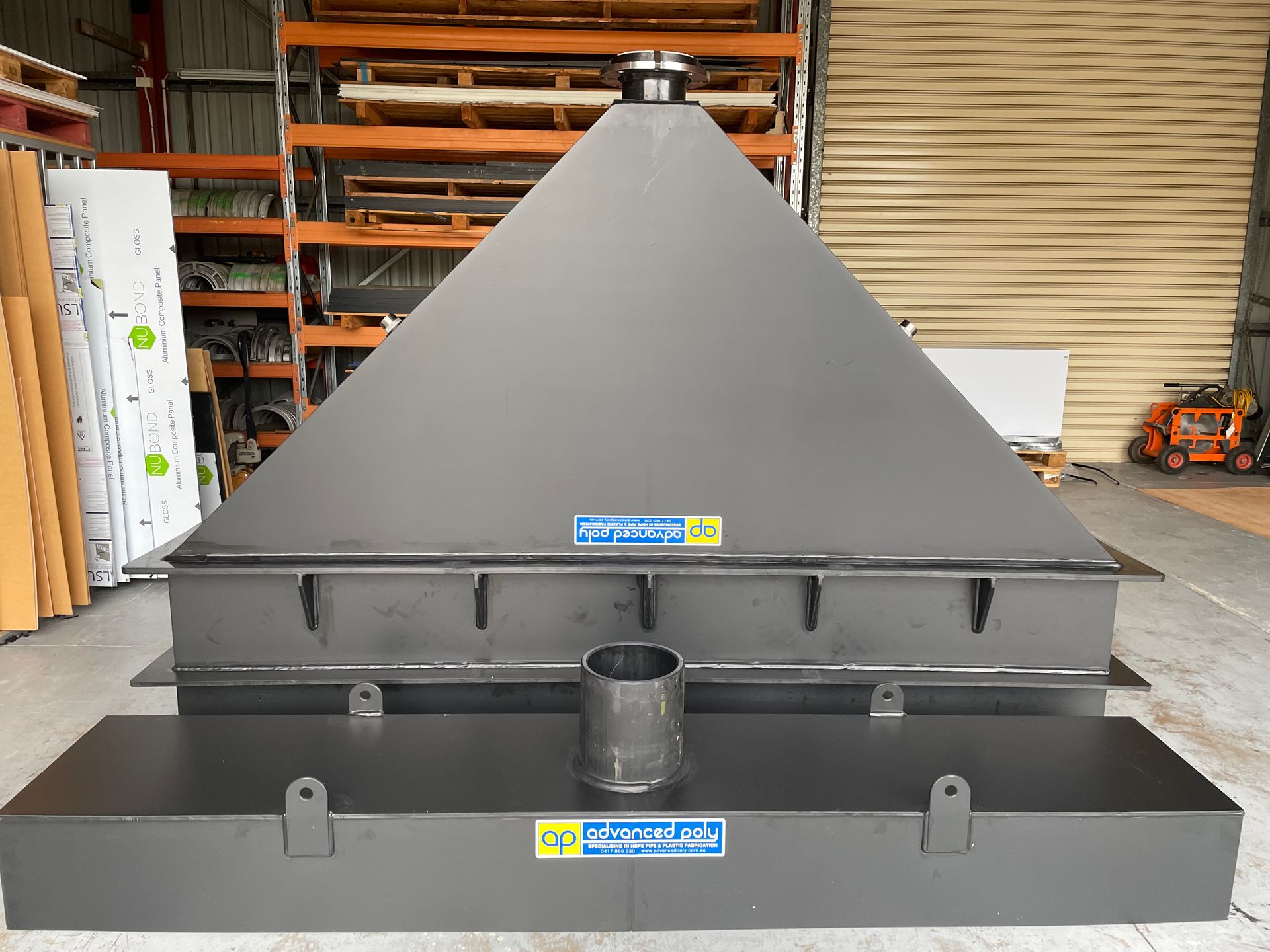 Large gray industrial metal hopper with a conical top in a warehouse. — Advanced Poly in Darwin, NT