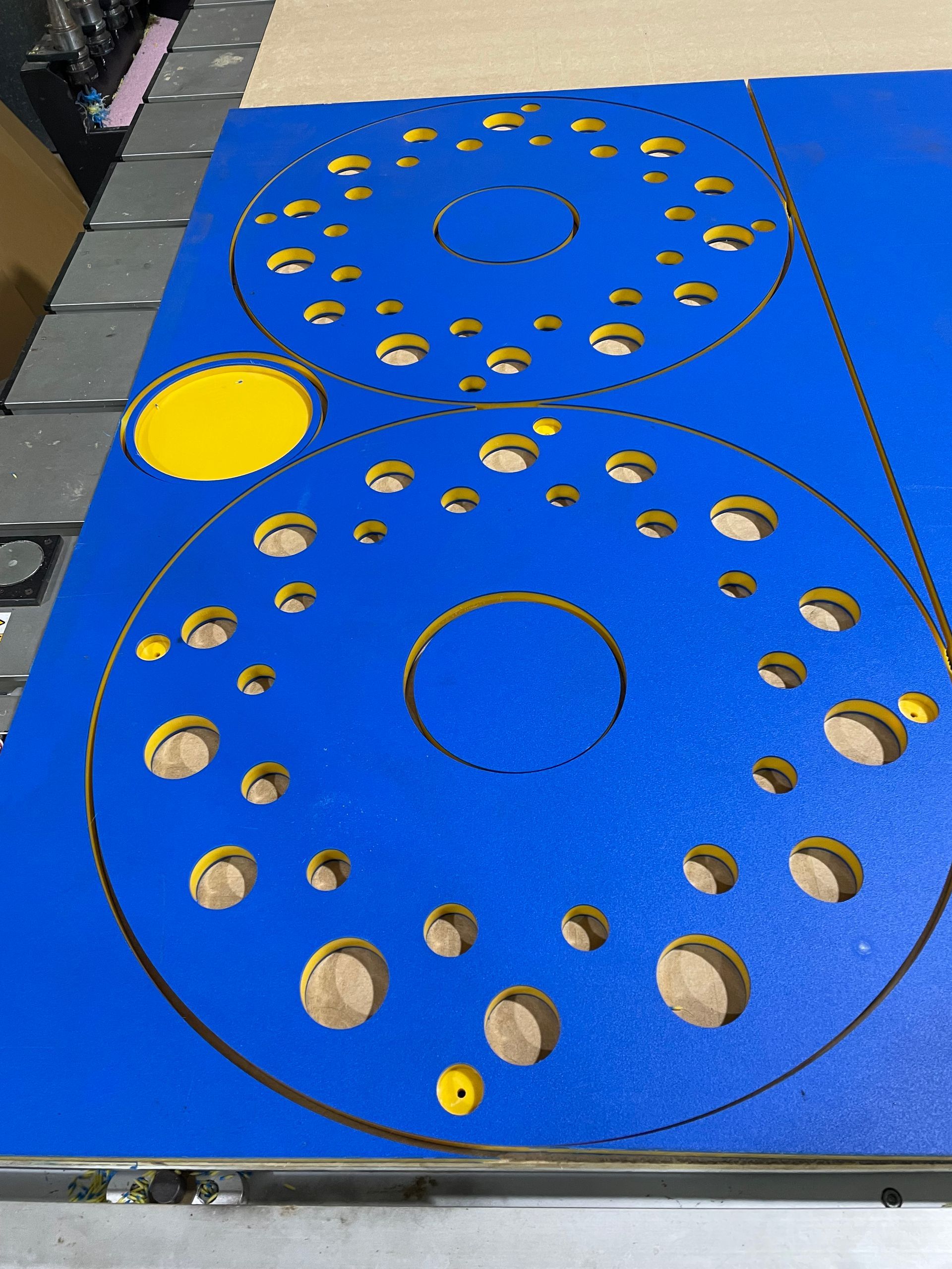 Blue perforated circular metal panel with two large circles and yellow inserts on the left edge — Advanced Poly in Darwin, NT — Advanced Poly in Darwin, NT