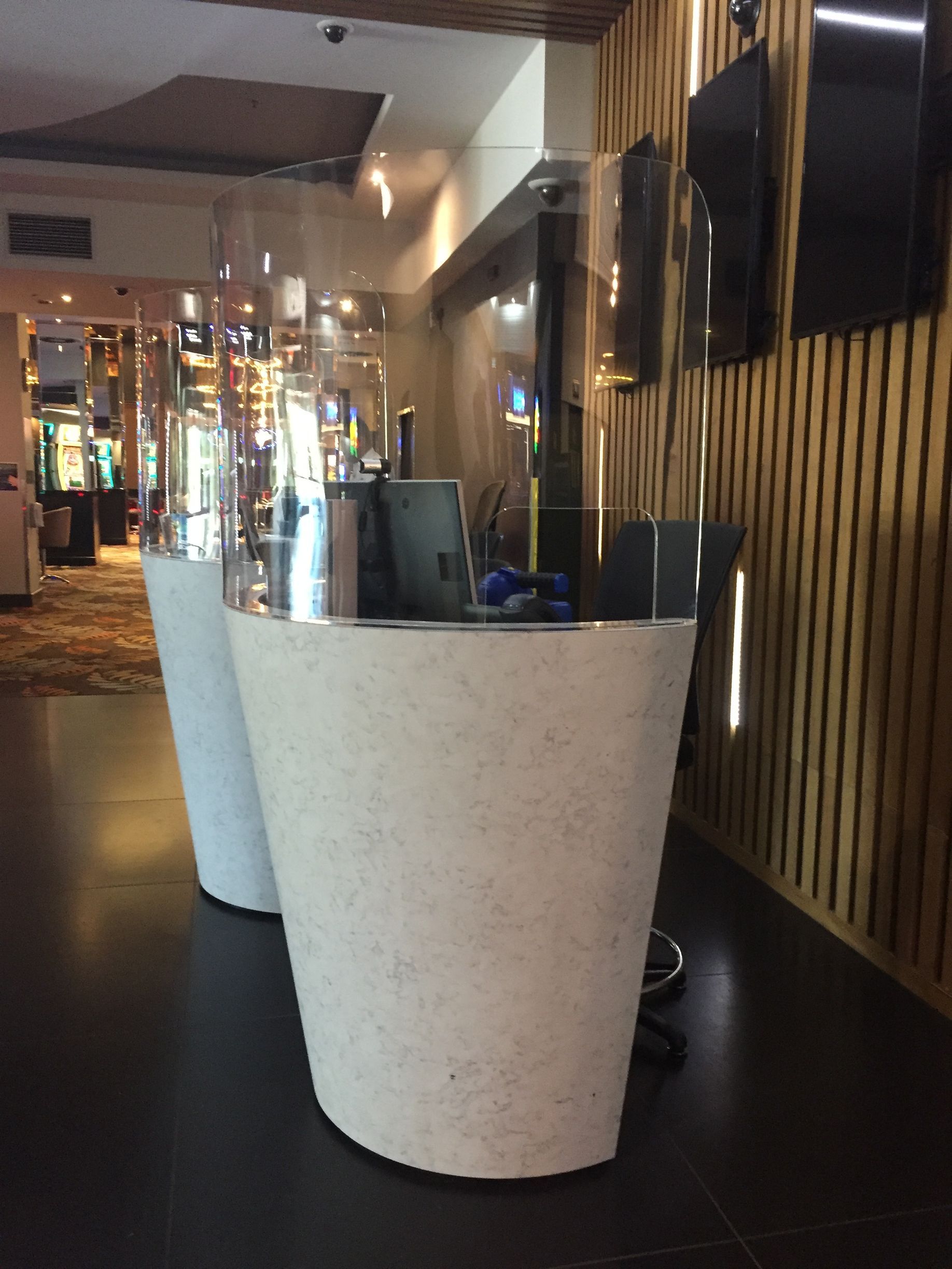 Modern lobby with a white curved reception desk and wood-paneled wall. — Advanced Poly in Darwin, NT
