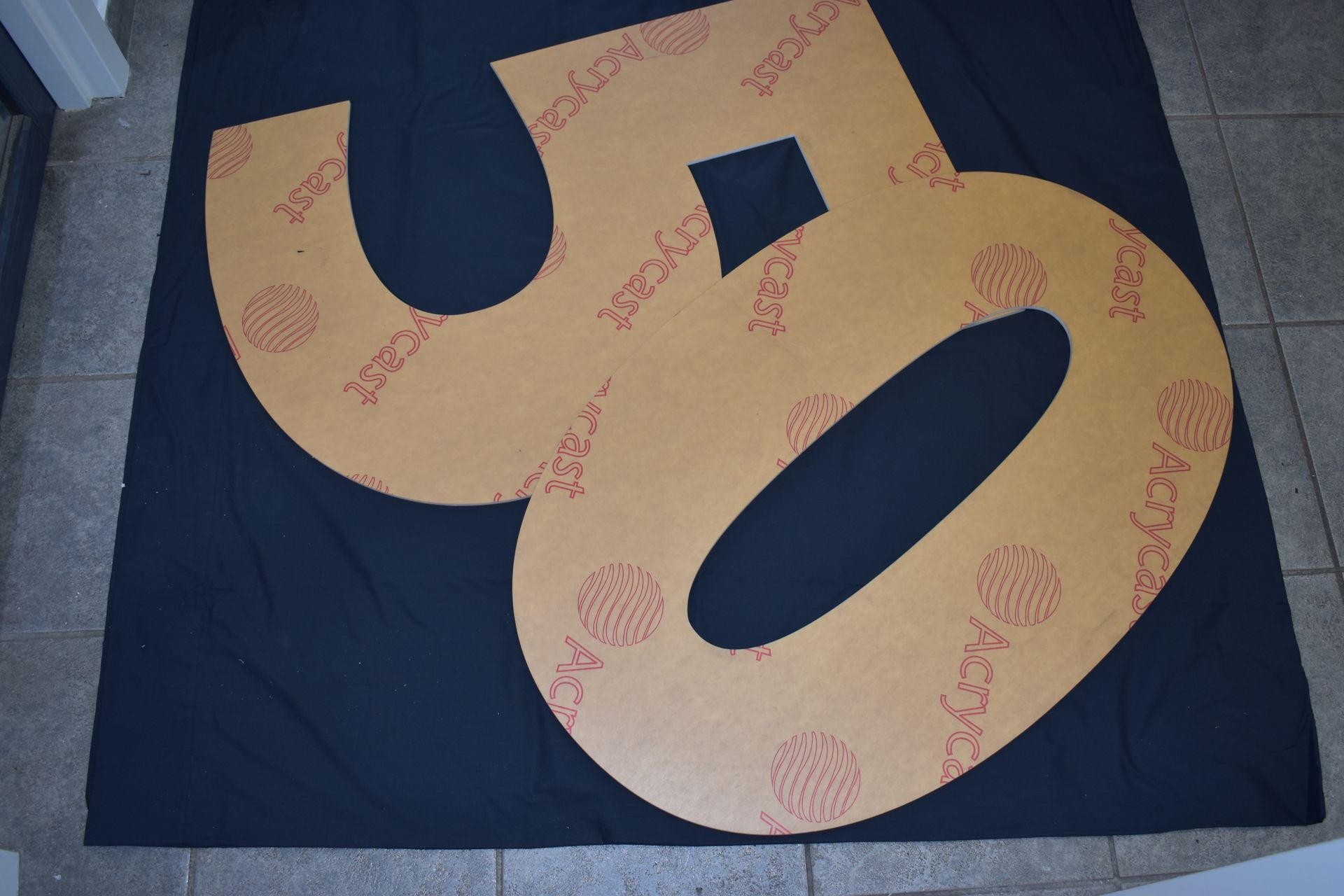 Yellow foam puzzle piece on a dark mat, printed with pink patterns and text. — Advanced Poly in Darwin, NT