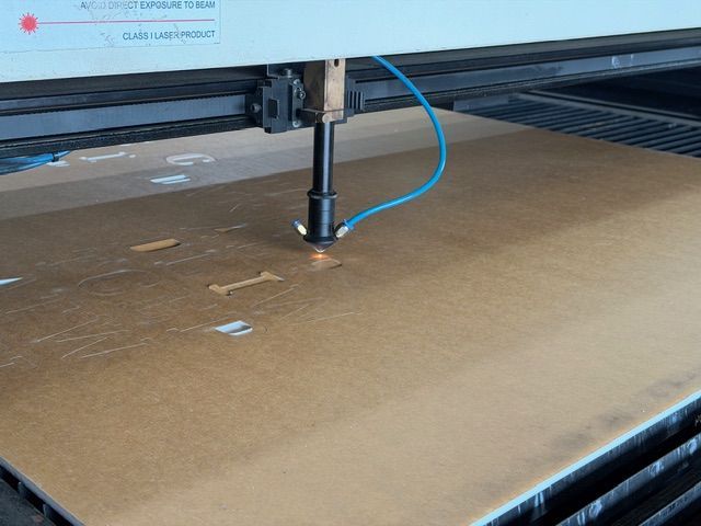 Laser cutter engraving cardboard on a work bed — Advanced Poly in Darwin, NT