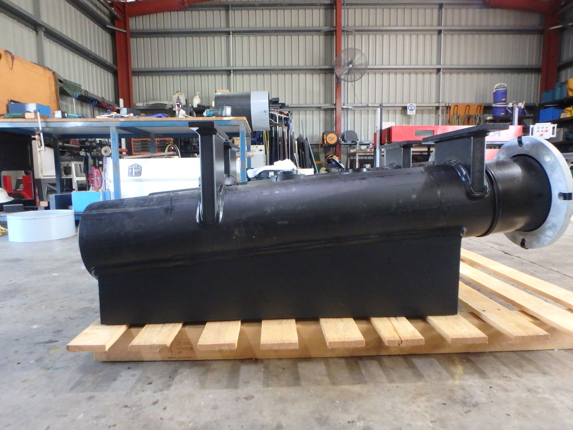 Black industrial metal tank or vessel on wooden pallet in a warehouse workshop — Advanced Poly in Darwin, NT — Advanced Poly in Darwin, NT 