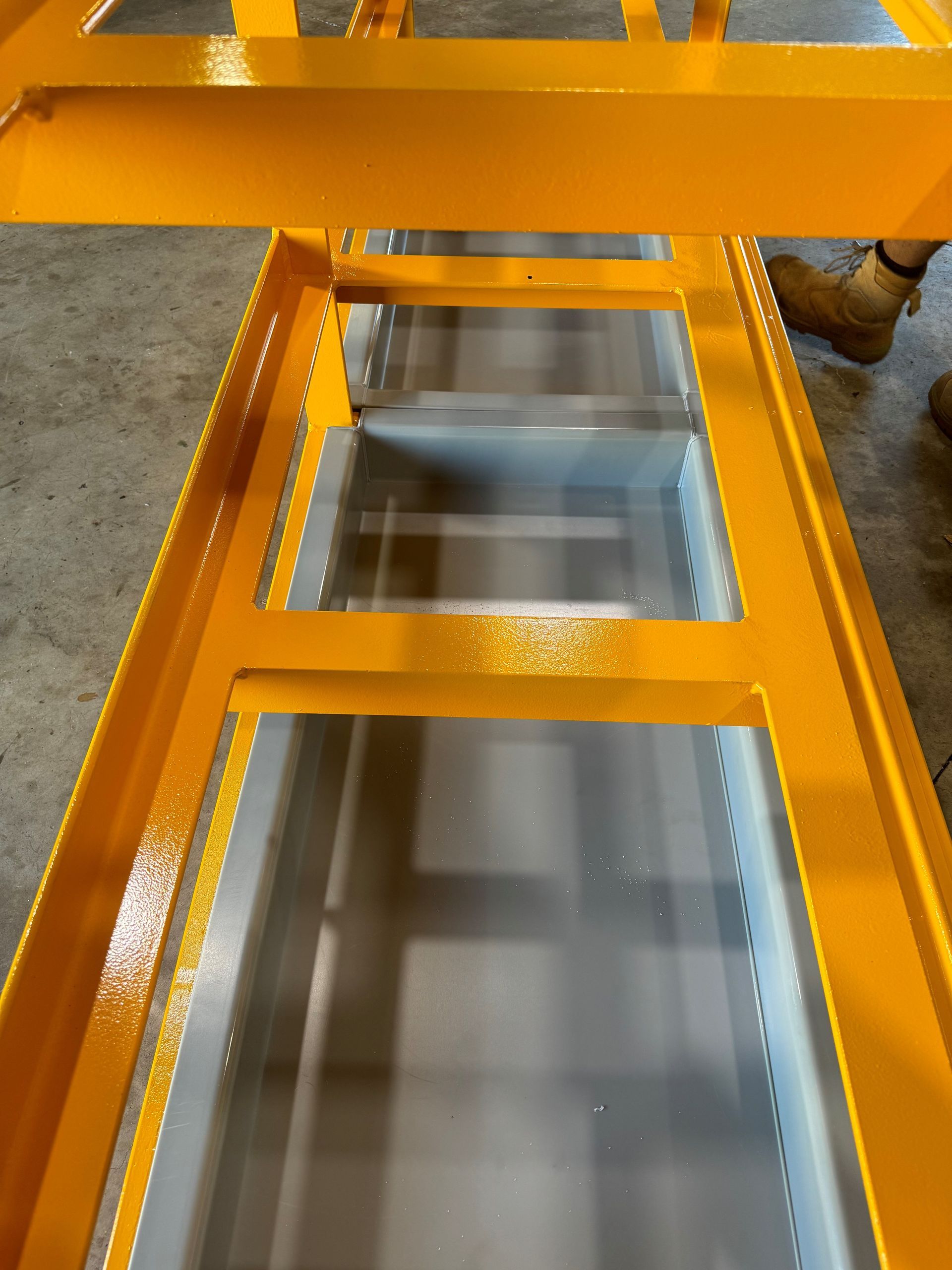 Orange metal frame over rectangular floor openings in an industrial setting — Advanced Poly in Darwin, NT — Advanced Poly in Darwin, NT 