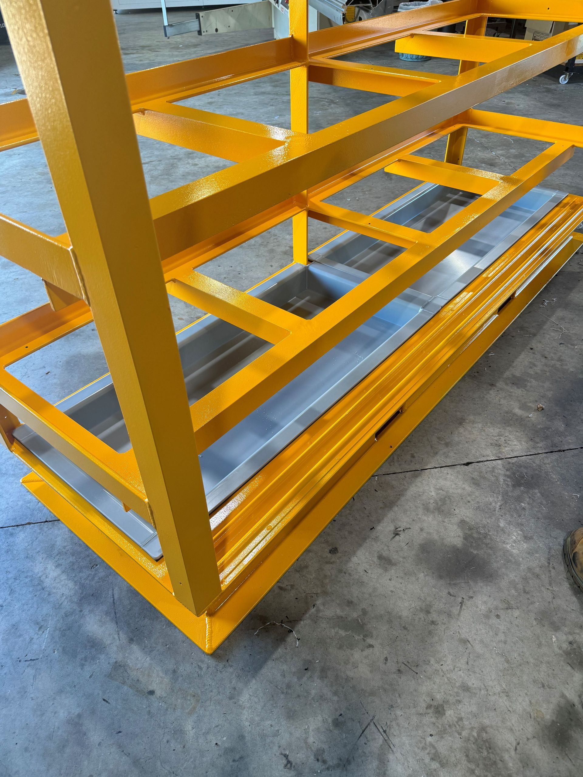 Yellow metal shelving rack on a concrete floor, shown at an angle. — Advanced Poly in Darwin, NT — Advanced Poly in Darwin, NT 