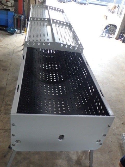 Perforated black metal industrial tray or enclosure on a workshop floor — Advanced Poly in Darwin, NT — Advanced Poly in Darwin, NT 