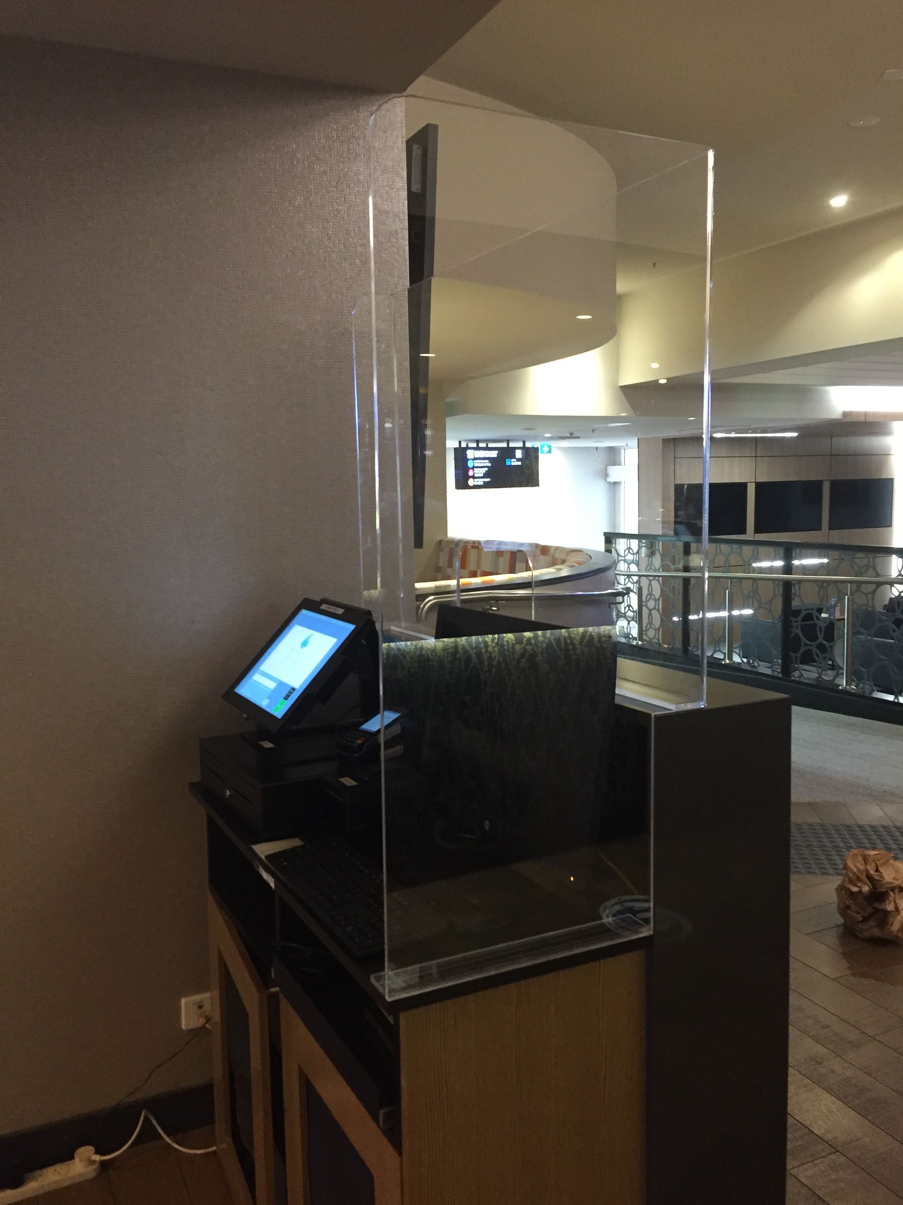 Hotel lobby check-in kiosk beside a glass-railed reception counter in a dim hallway — Advanced Poly in Darwin, NT — Advanced Poly in Darwin, NT 