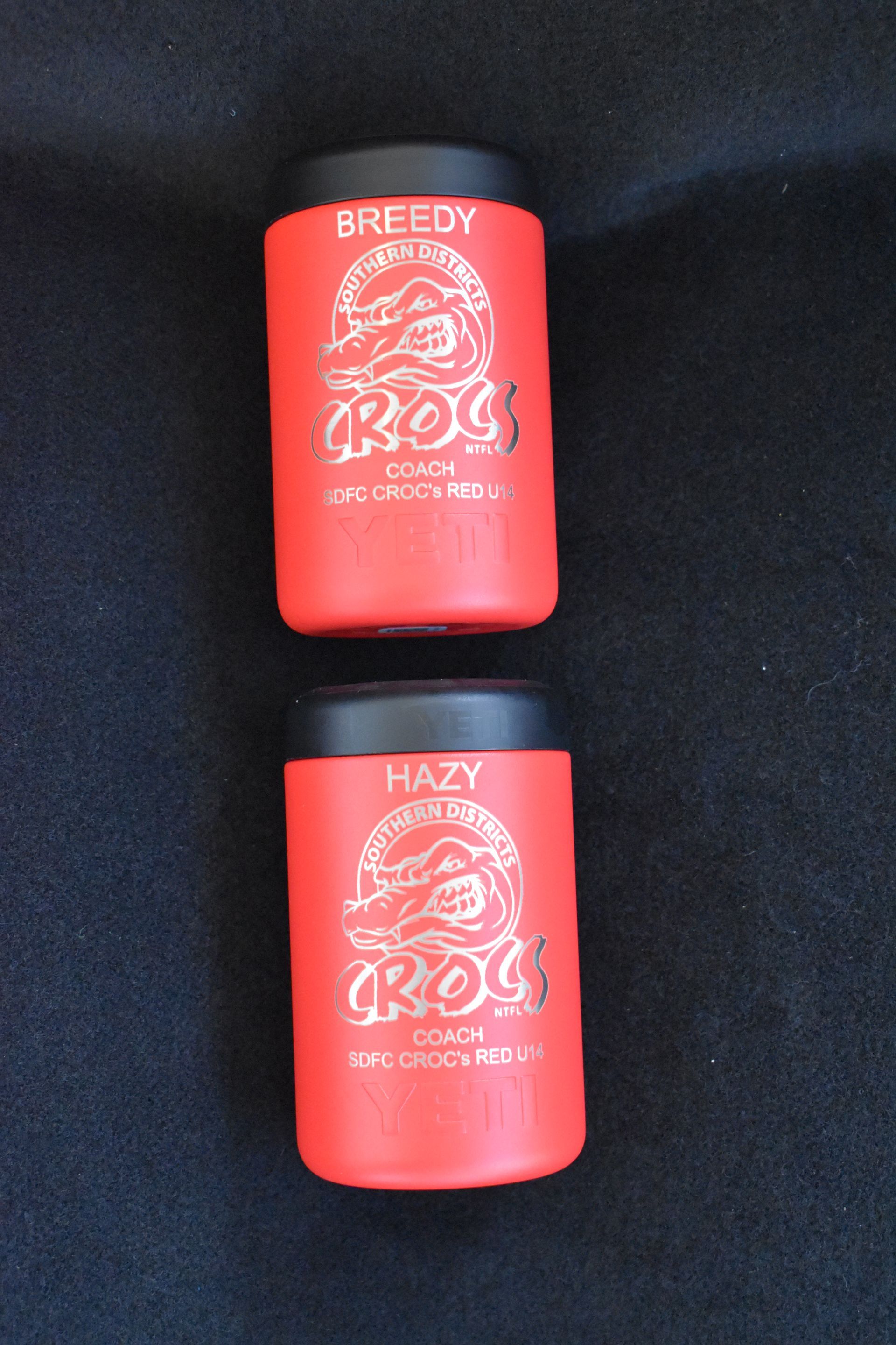 Two red Crocs-branded containers on a black background, labeled Greedy and Hazy. — Advanced Poly in Darwin, NT 