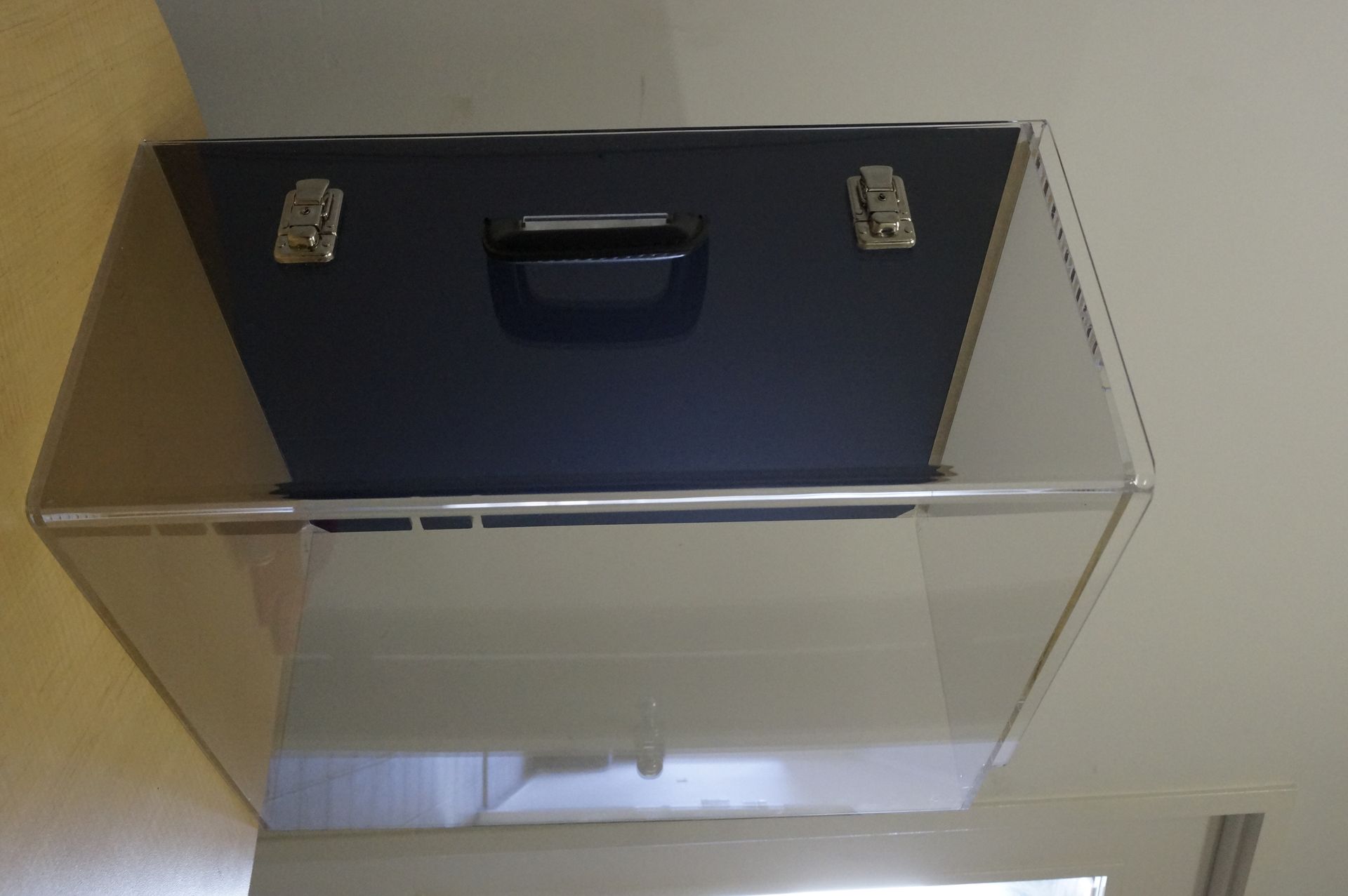 Transparent wall-mounted storage bin with a black top panel and handle against a white wall — Advanced Poly in Darwin, NT — Advanced Poly in Darwin, NT 