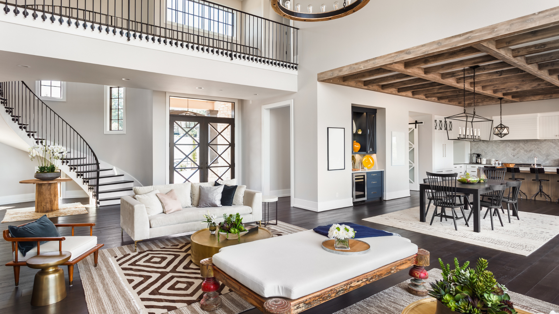 Spacious living room with staircase, sofa, dining area, and decorative ceiling.