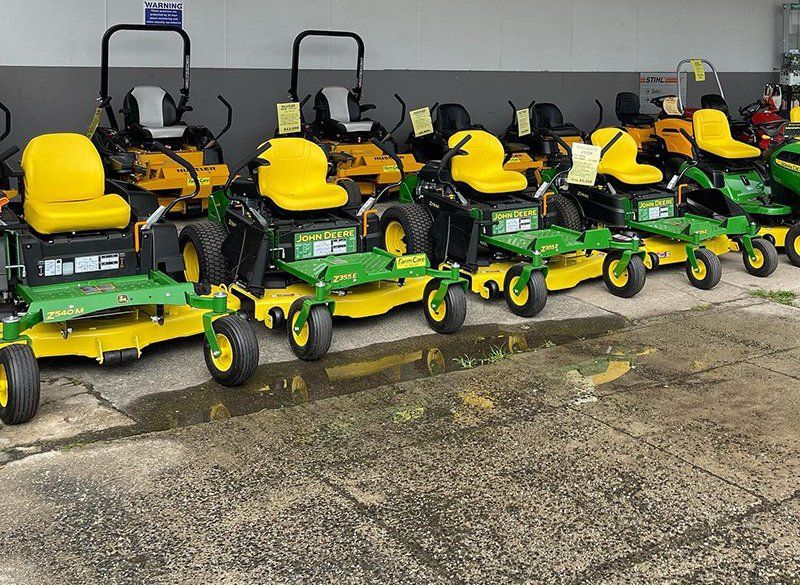 A Row of John Deere Lawn Mowers Are Parked in Front of a Building — FarmCare in Mullumbimby, NSW