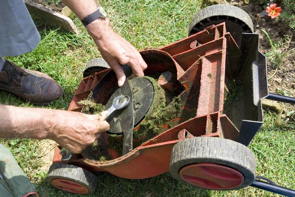 Man Repairing Push Lawn Mower — FarmCare in Mullumbimby, NSW