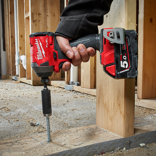 A Person is Using a Milwaukee Drill to Drill a Hole in a Wooden Post — FarmCare in Mullumbimby, NSW