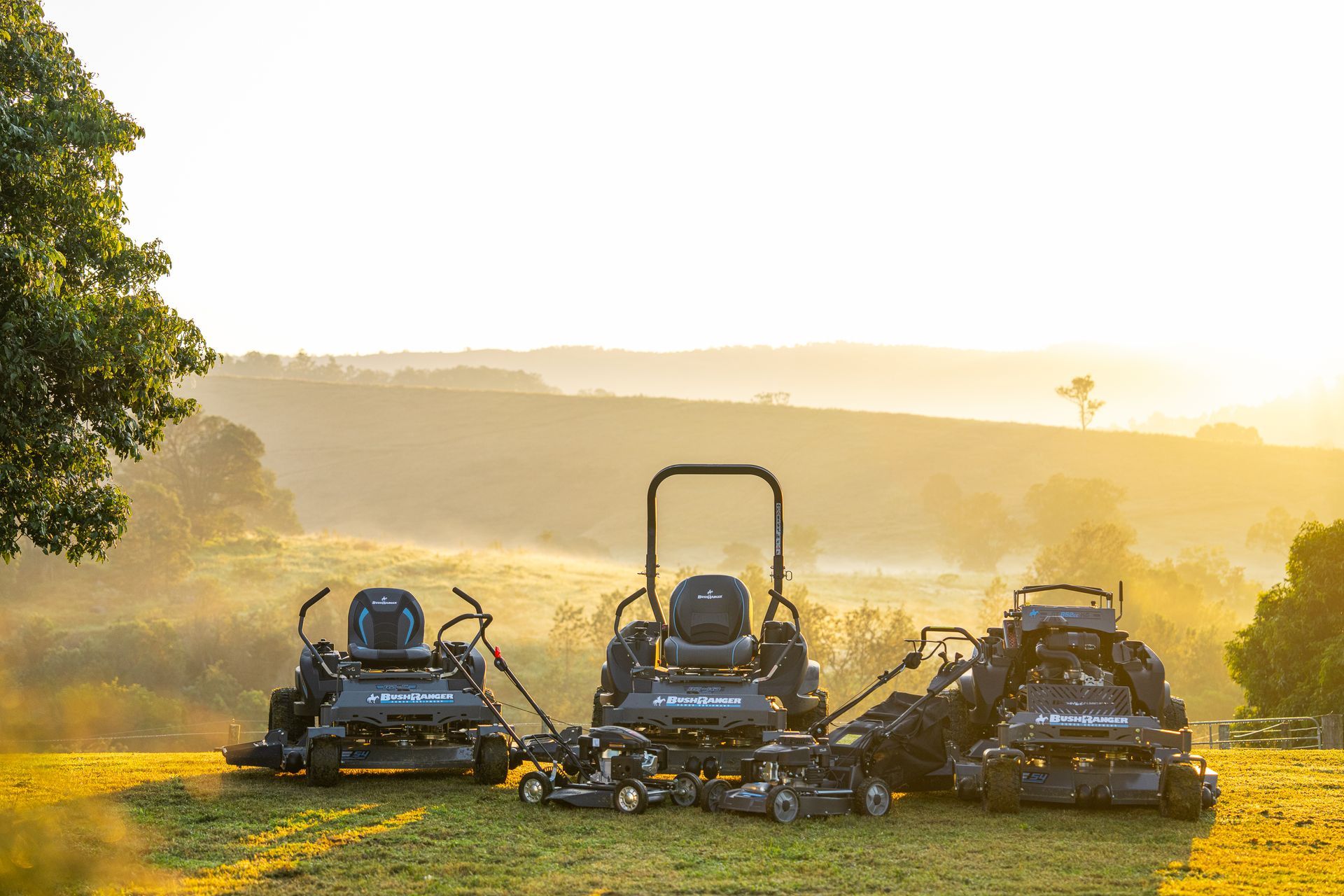 Three Lawn Mowers Are Parked in a Grassy Field at Sunset — FarmCare in Mullumbimby, NSW