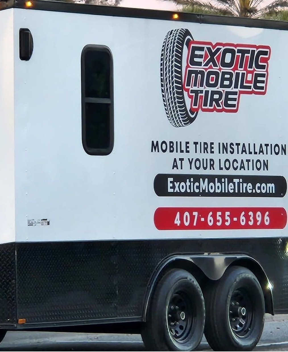A white and black mobile tire trailer with