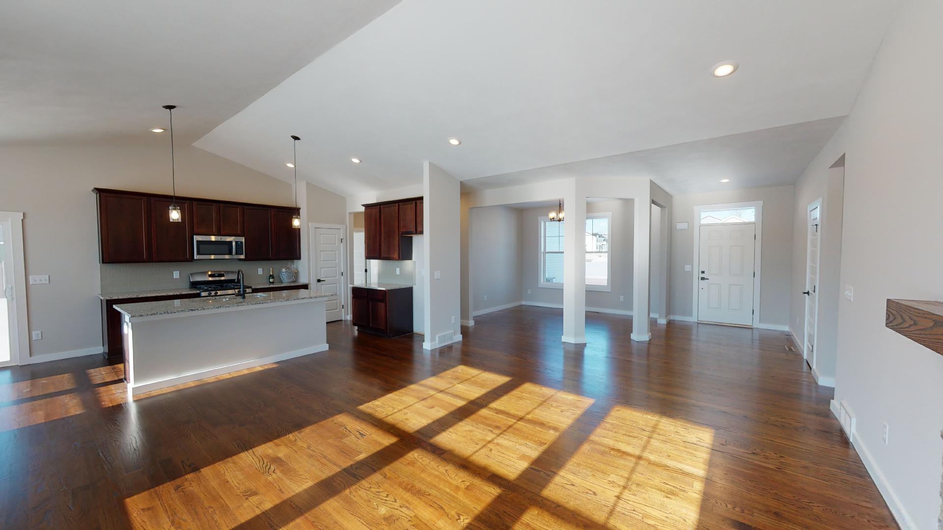living room with kitchen, dinning room, and front entryway in background