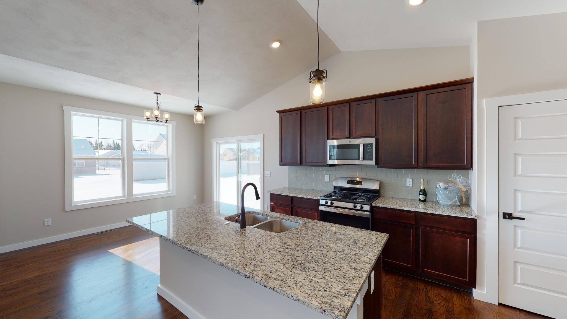 kitchen with vaulted ceilings and dinette in background