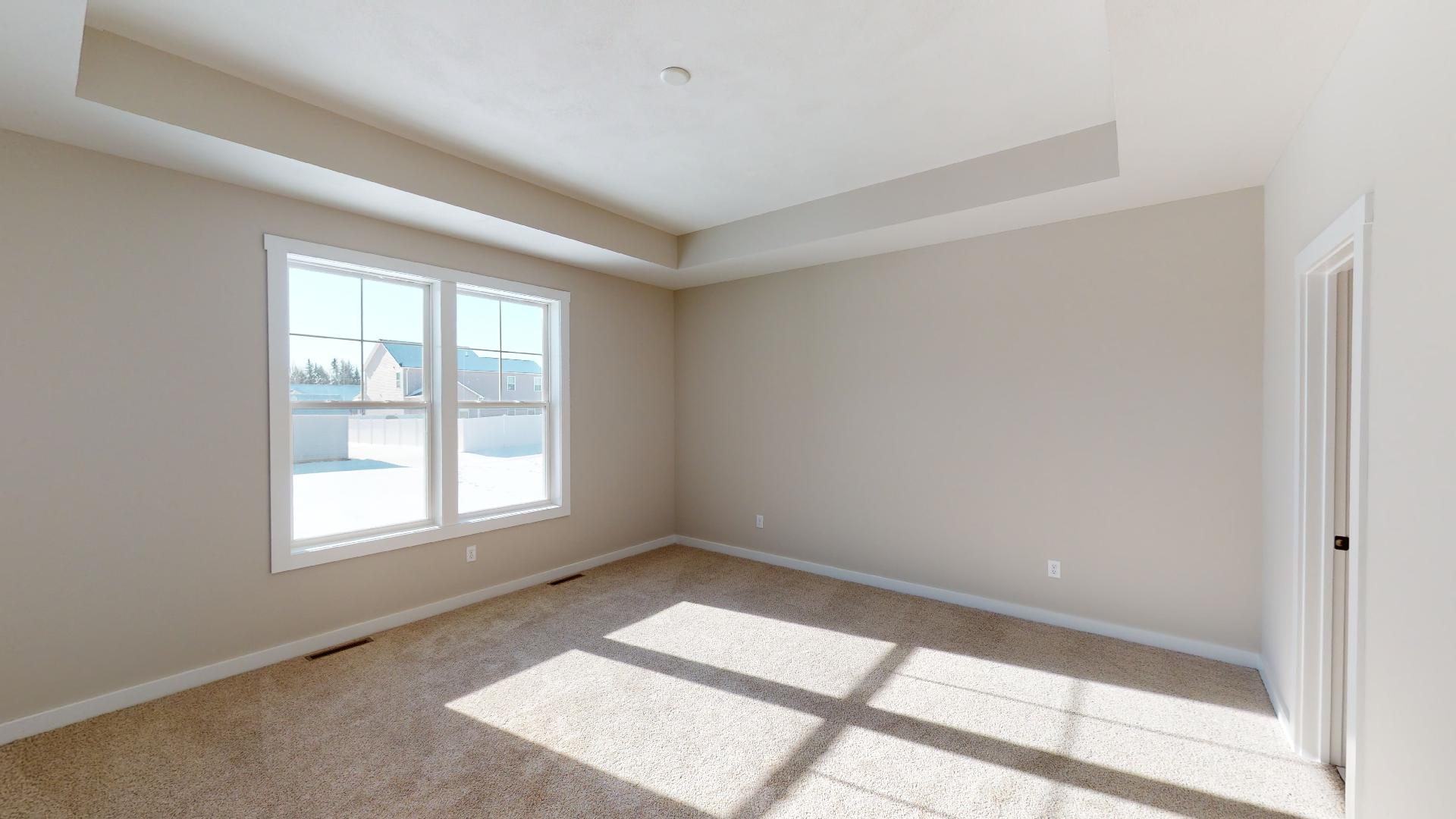 primary bedroom with recessed ceiling