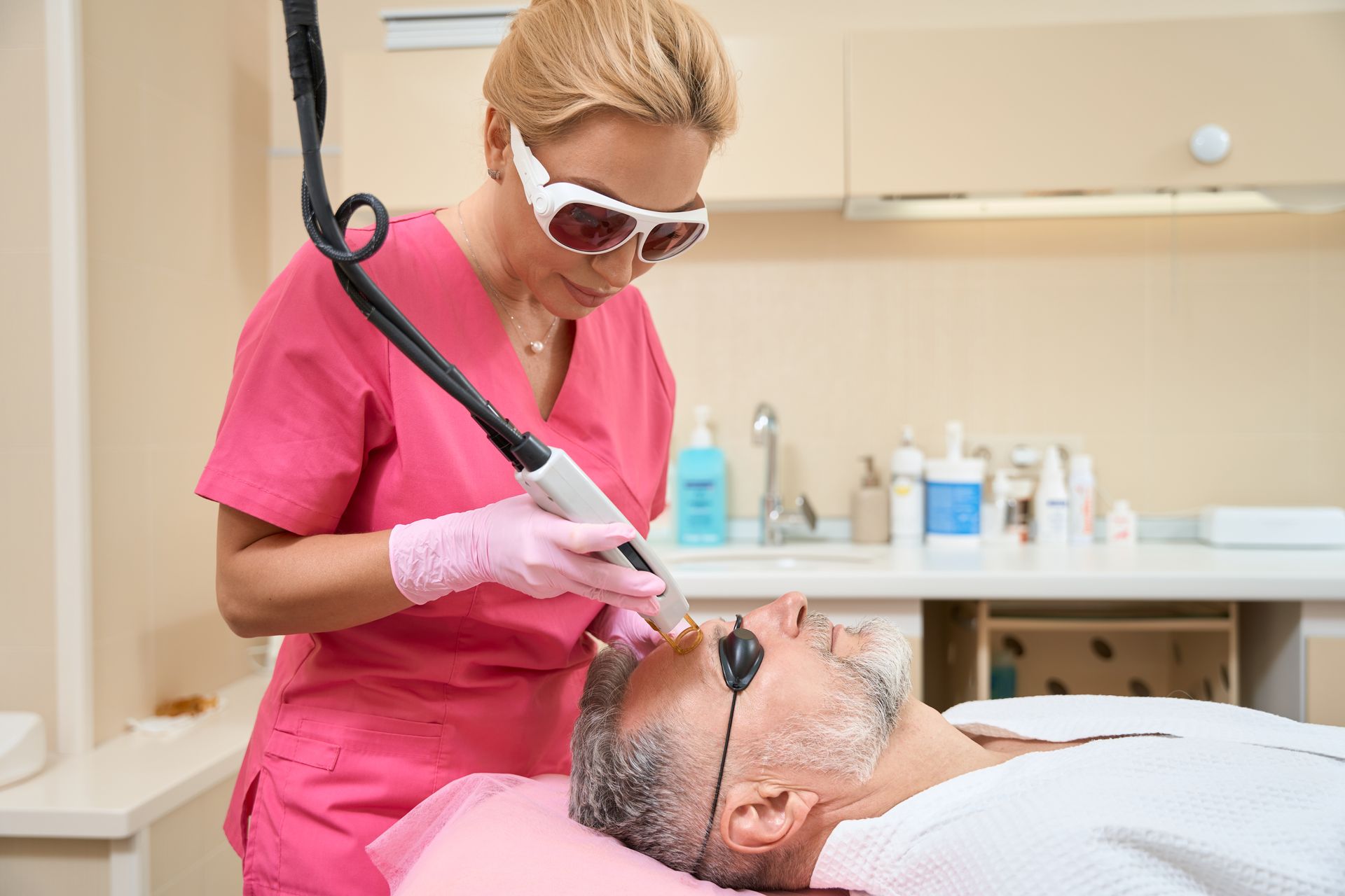 A man is getting a laser treatment on his face.