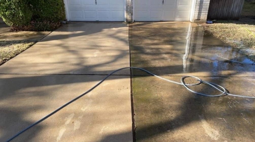 A before and after picture of a concrete driveway being cleaned with a pressure washer.