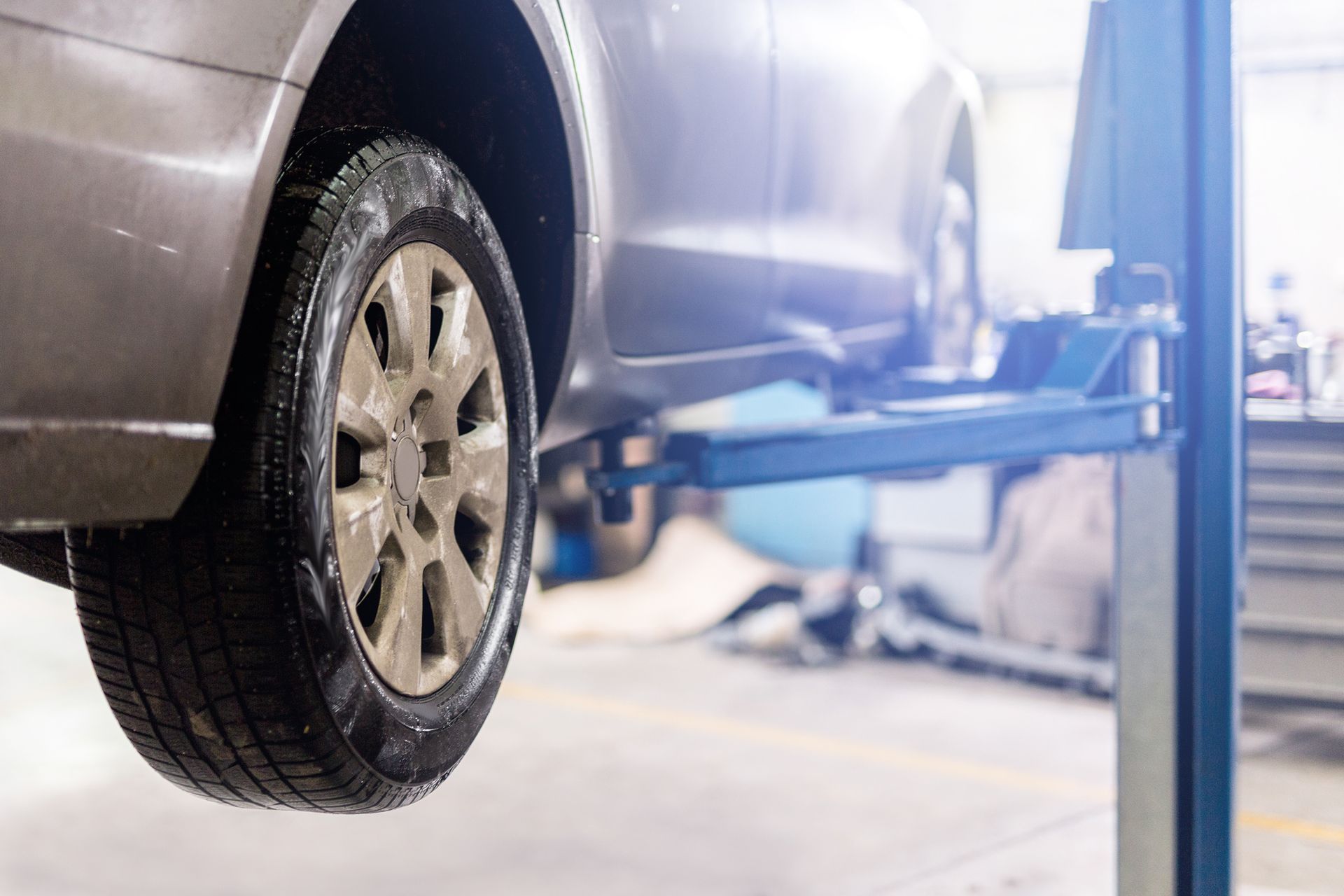 A car is sitting on a lift in a garage.