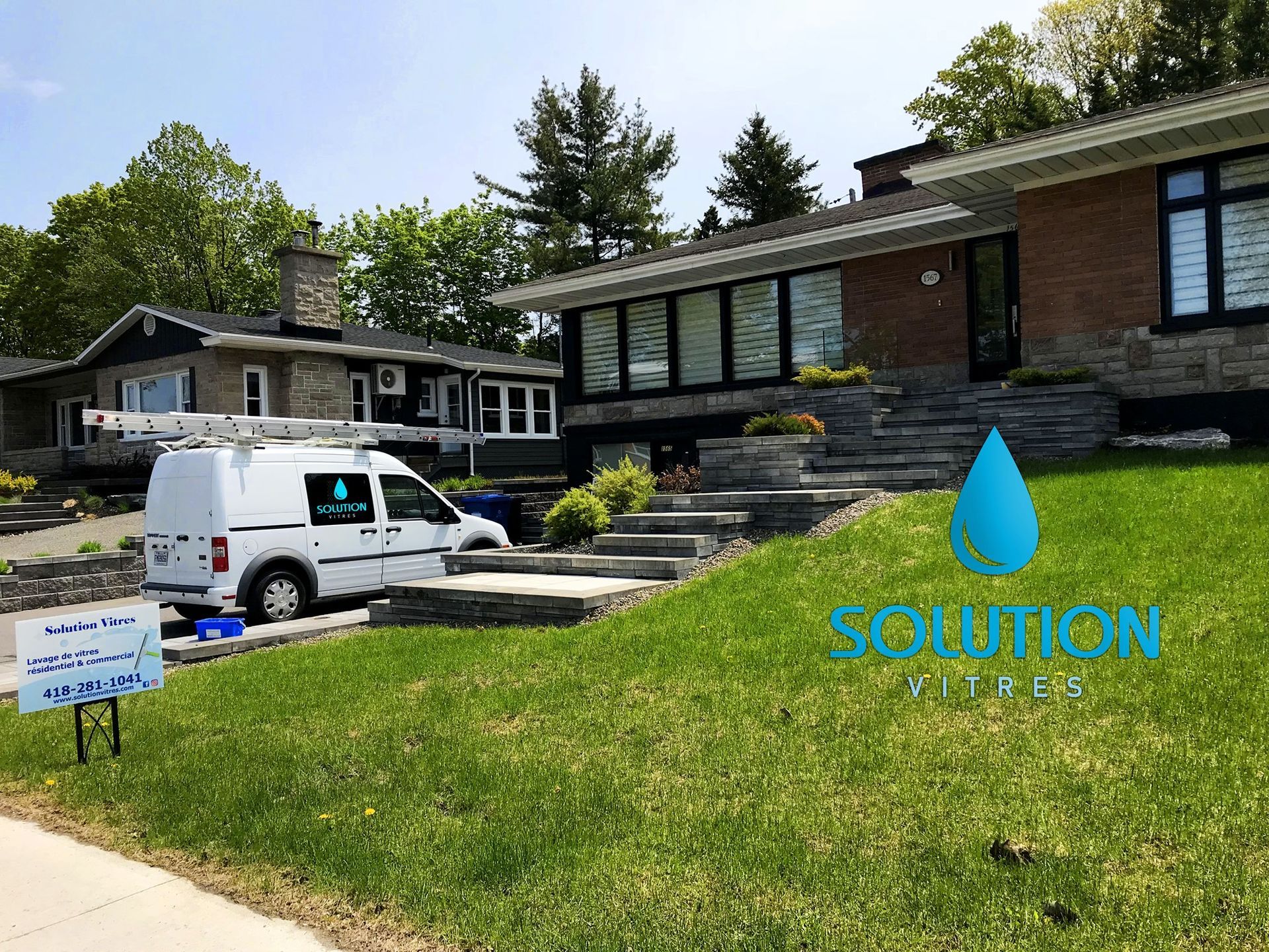 Une camionnette utilitaire blanche est garée devant une maison sur une pelouse en pente, avec un logo bleu « SOLUTION ».