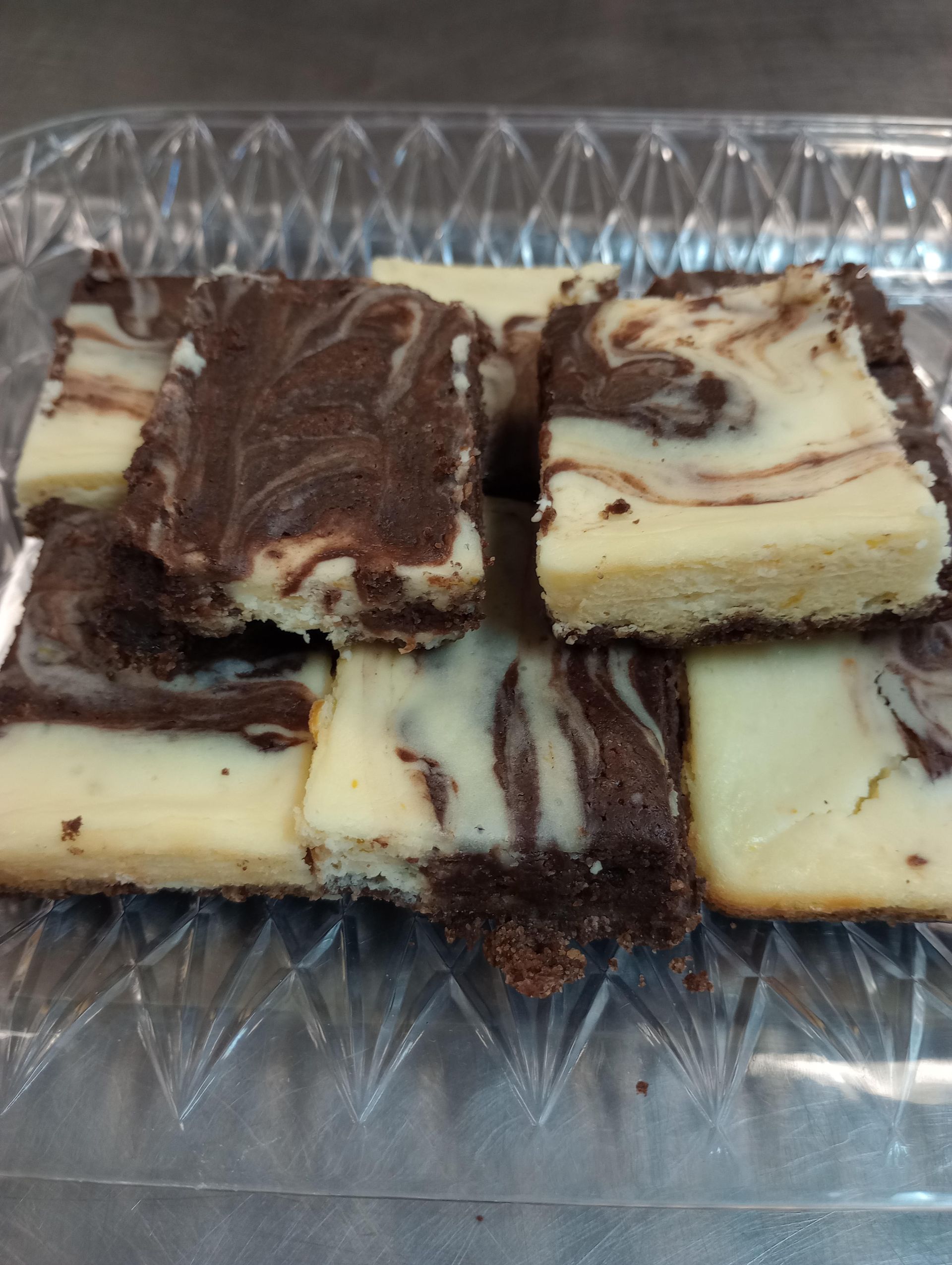 Swirled chocolate and cream cheese brownies in a clear plastic container.