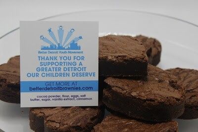 Brownies on a plate next to a card that says 