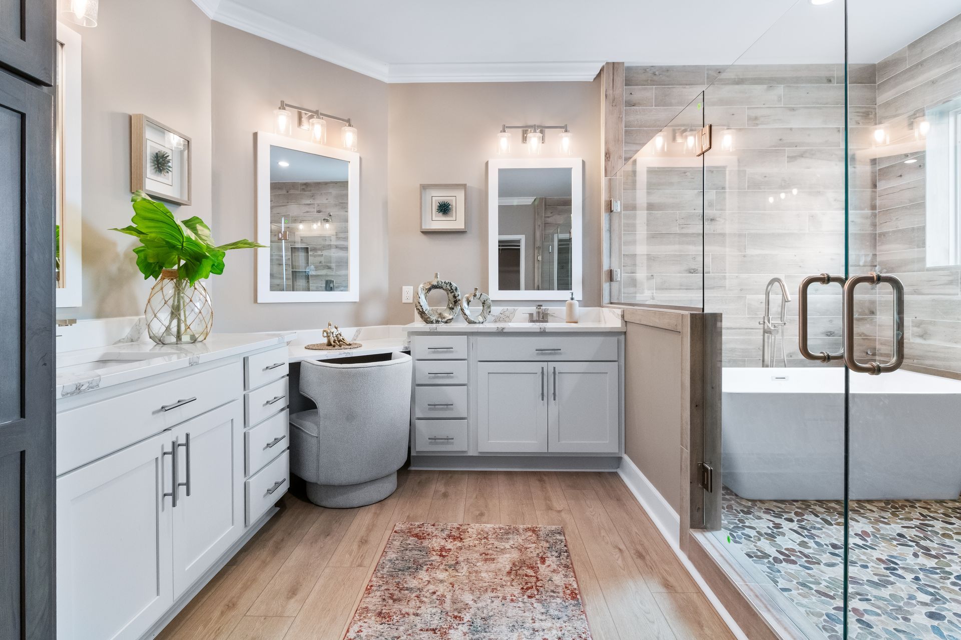 Modern bathroom with double vanity, freestanding tub, glass shower, and white-gray tile.