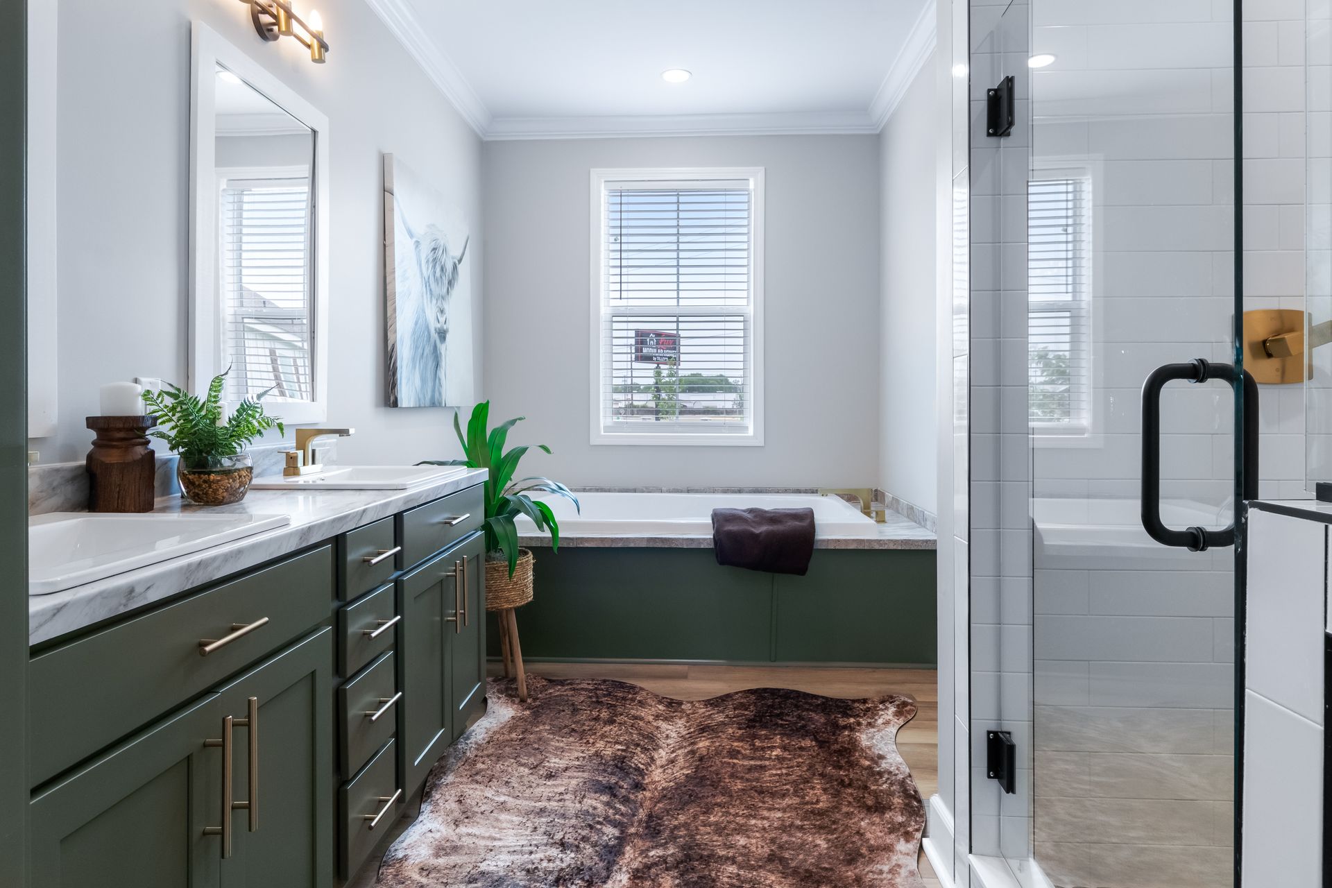 Modern bathroom with green vanity, white tile shower, and freestanding tub by a window