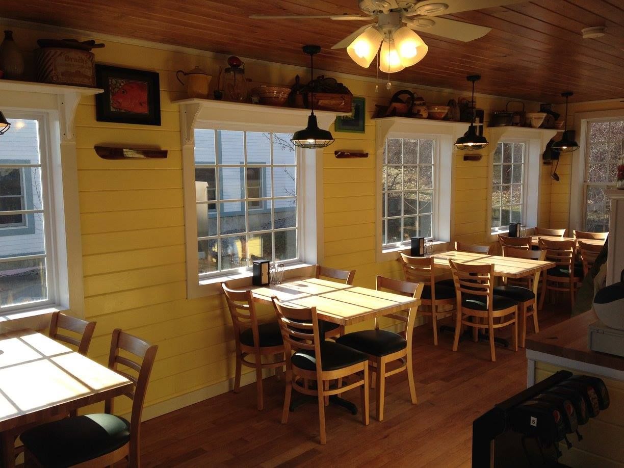 A restaurant with tables and chairs and a ceiling fan