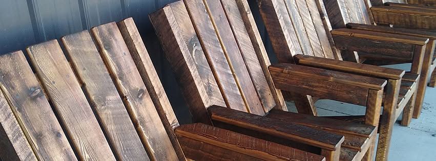 Row of weathered wooden rocking chairs lined up on a porch