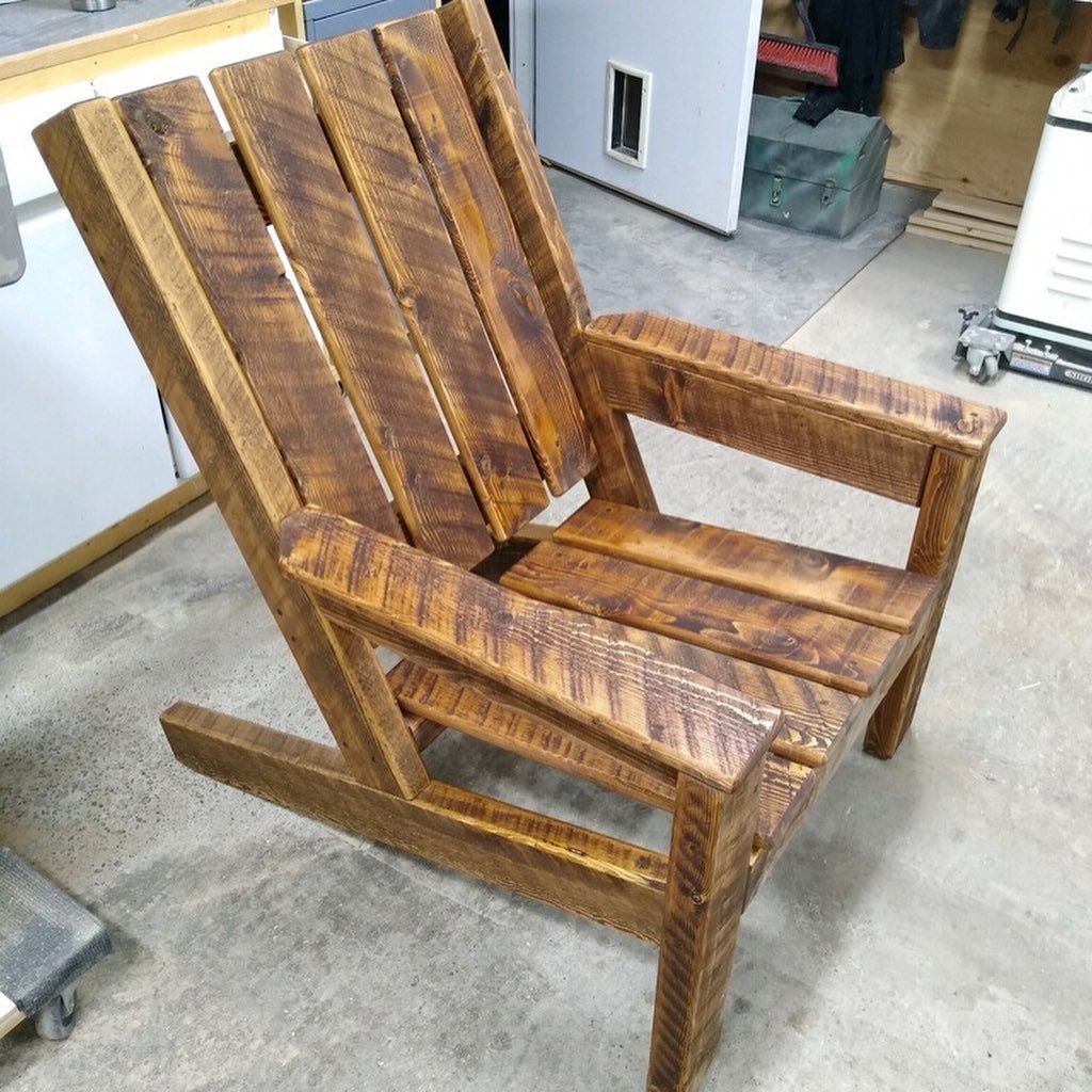 Wooden rocking chair with slatted back and arms, shown in a workshop or garage.