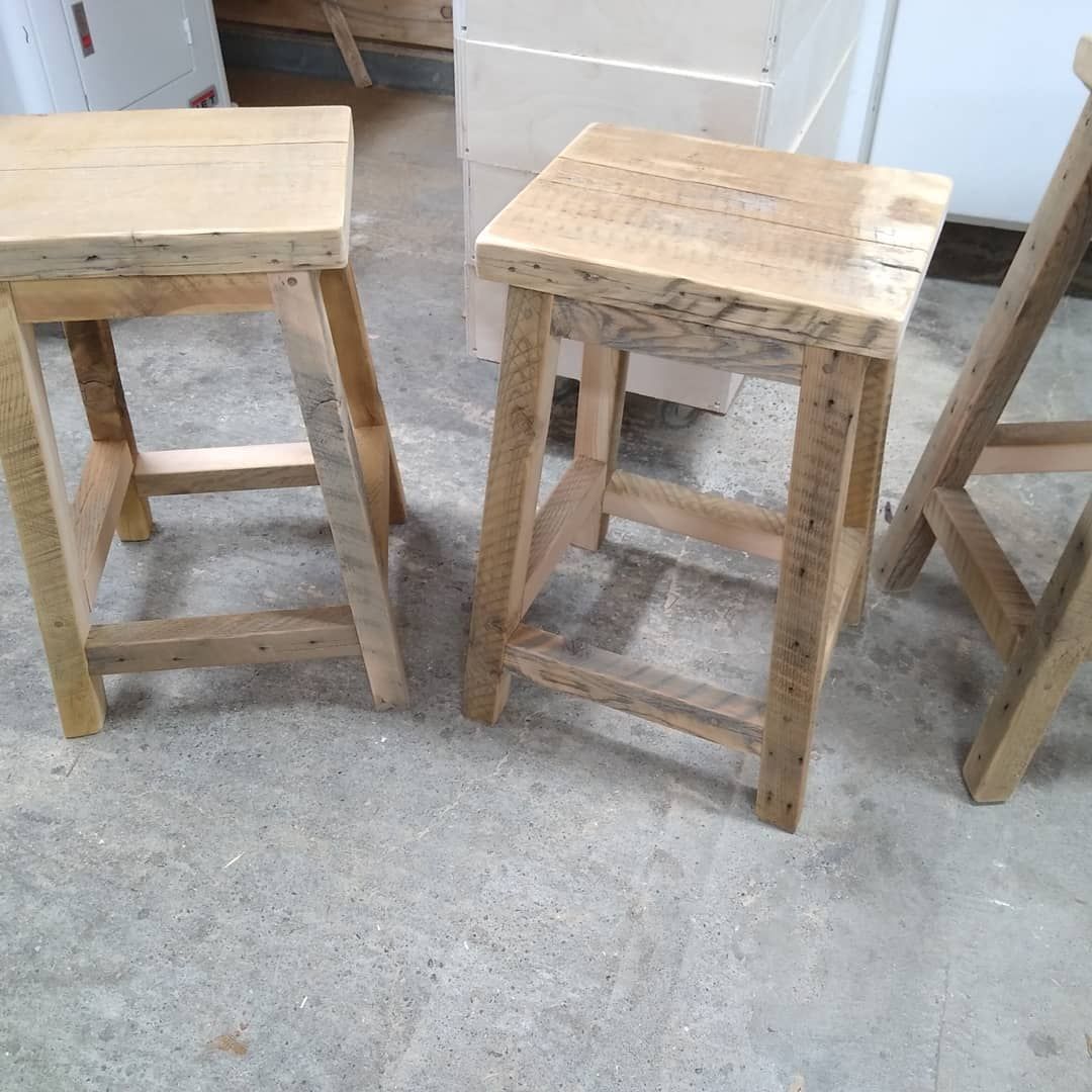 Three wooden stools in a workshop, viewed from above on a concrete floor.