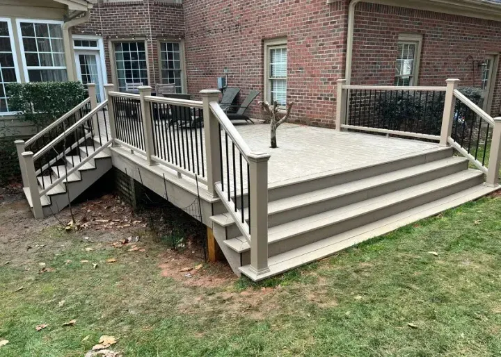 Brick backyard deck with stairs, railings, and a ramp beside a house