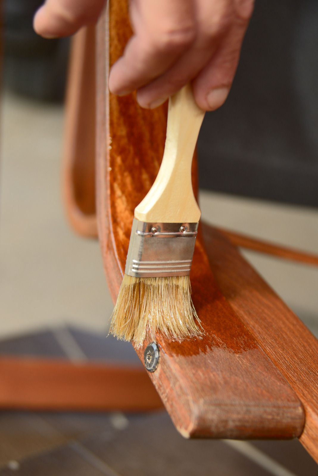 Hand brushing varnish onto a wooden furniture frame