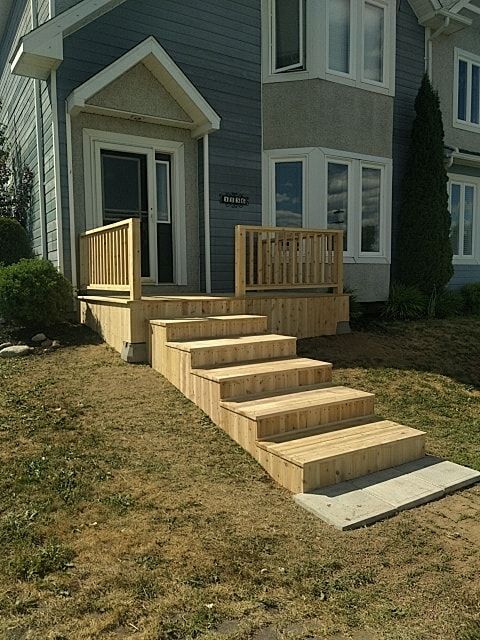 Outdoor wooden staircase leading to the entrance of a residential house.