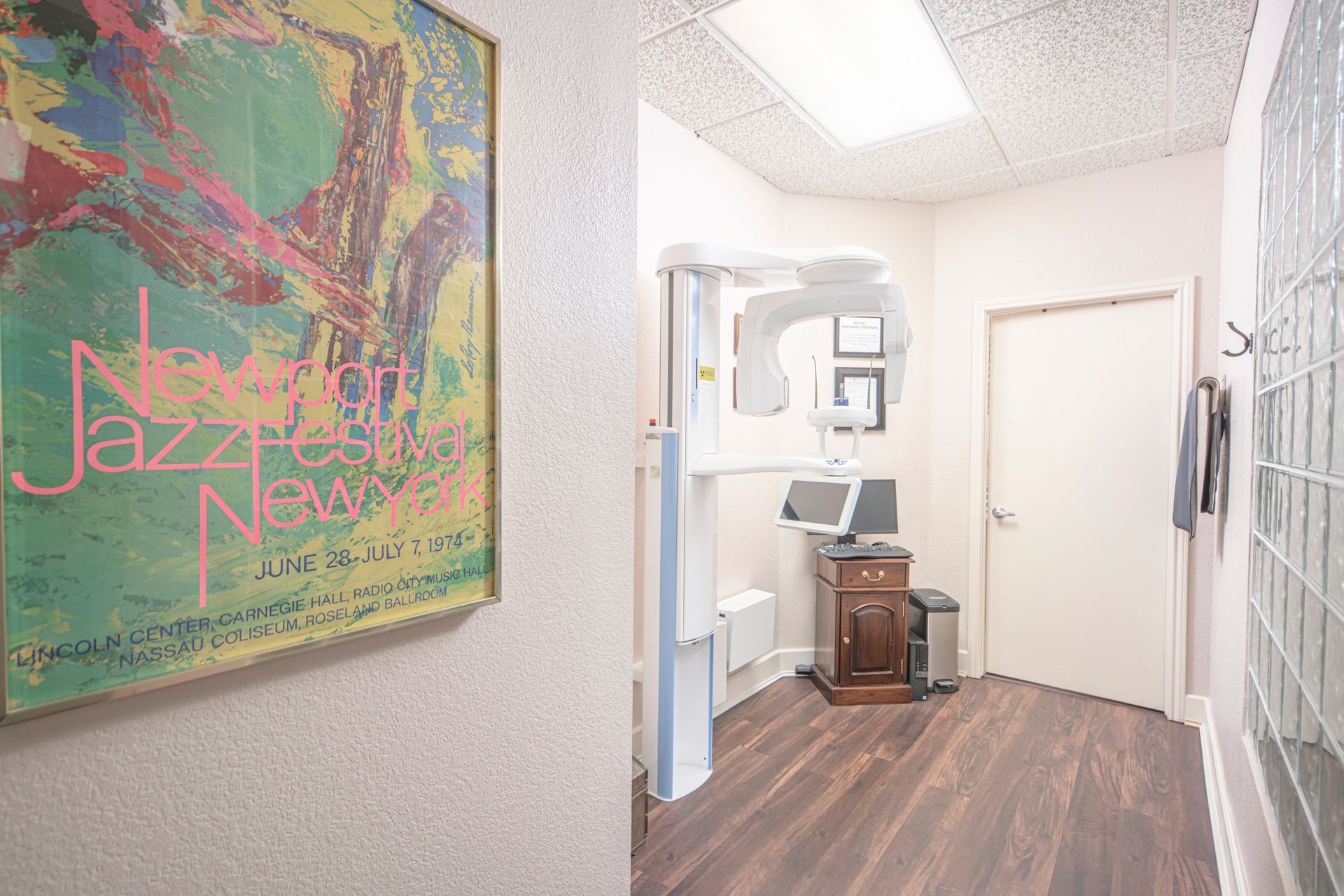 A hallway in a dental office with a painting on the wall.