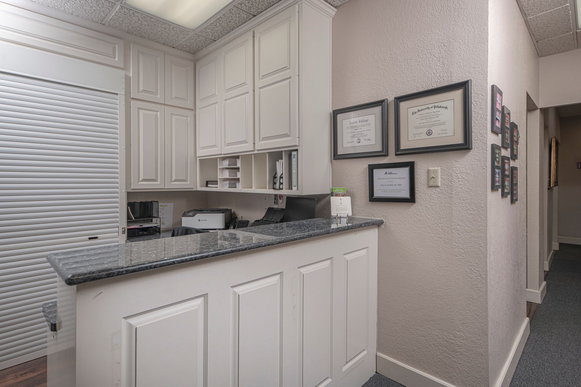 A kitchen with white cabinets and a counter top.